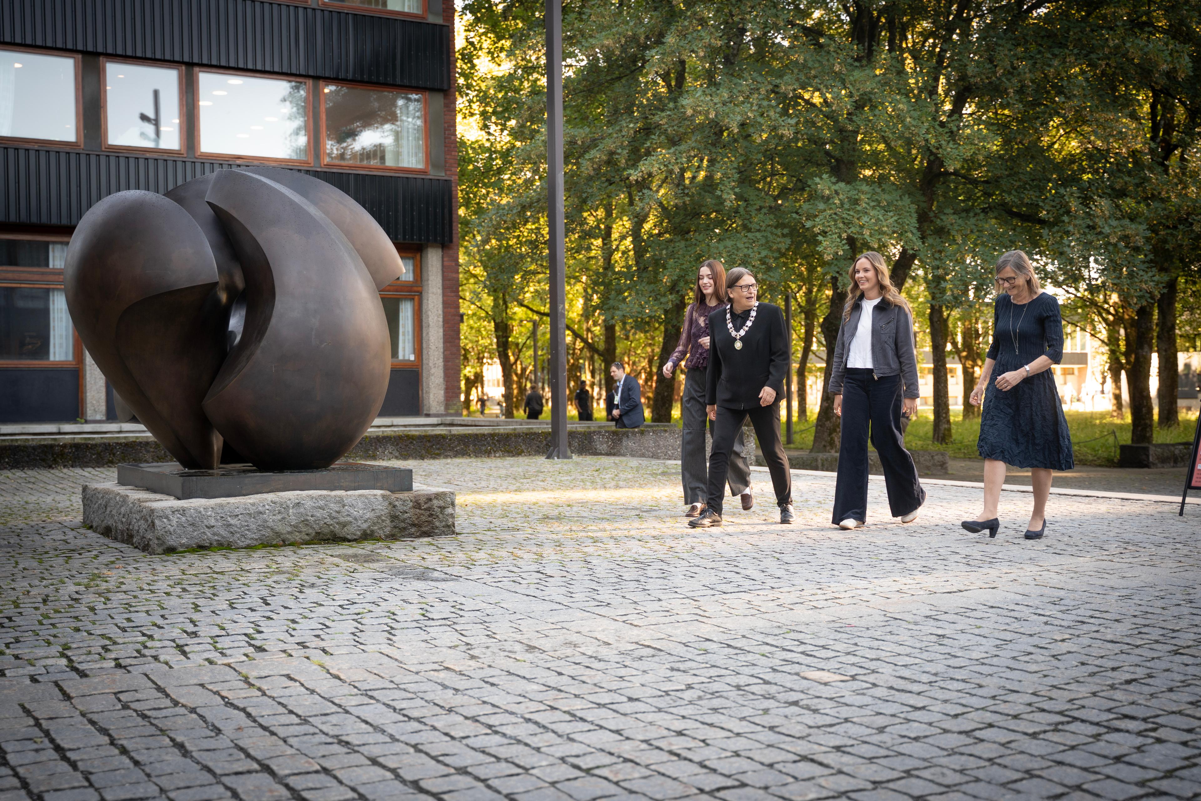 Anna Bergum Furset, Ragnhild Hennum, Prinsesse Ingrid Alexandra og Anne Julie Semb kommer gående. En statue sees i bakgrunnen.