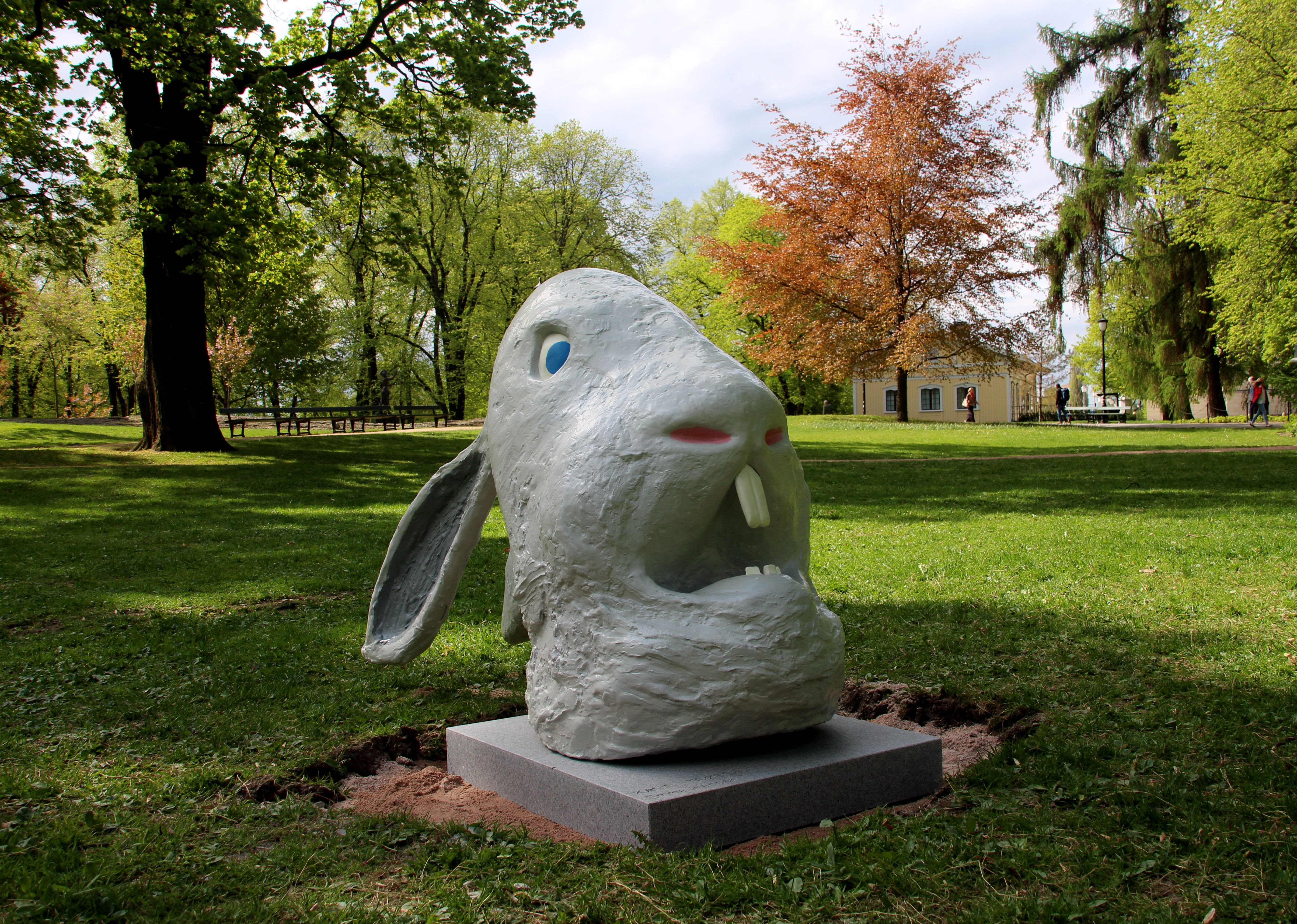 Skulpturen viser et stort, hvitt kaninhode med store fortenner, lange ører og en forskrekket mine.