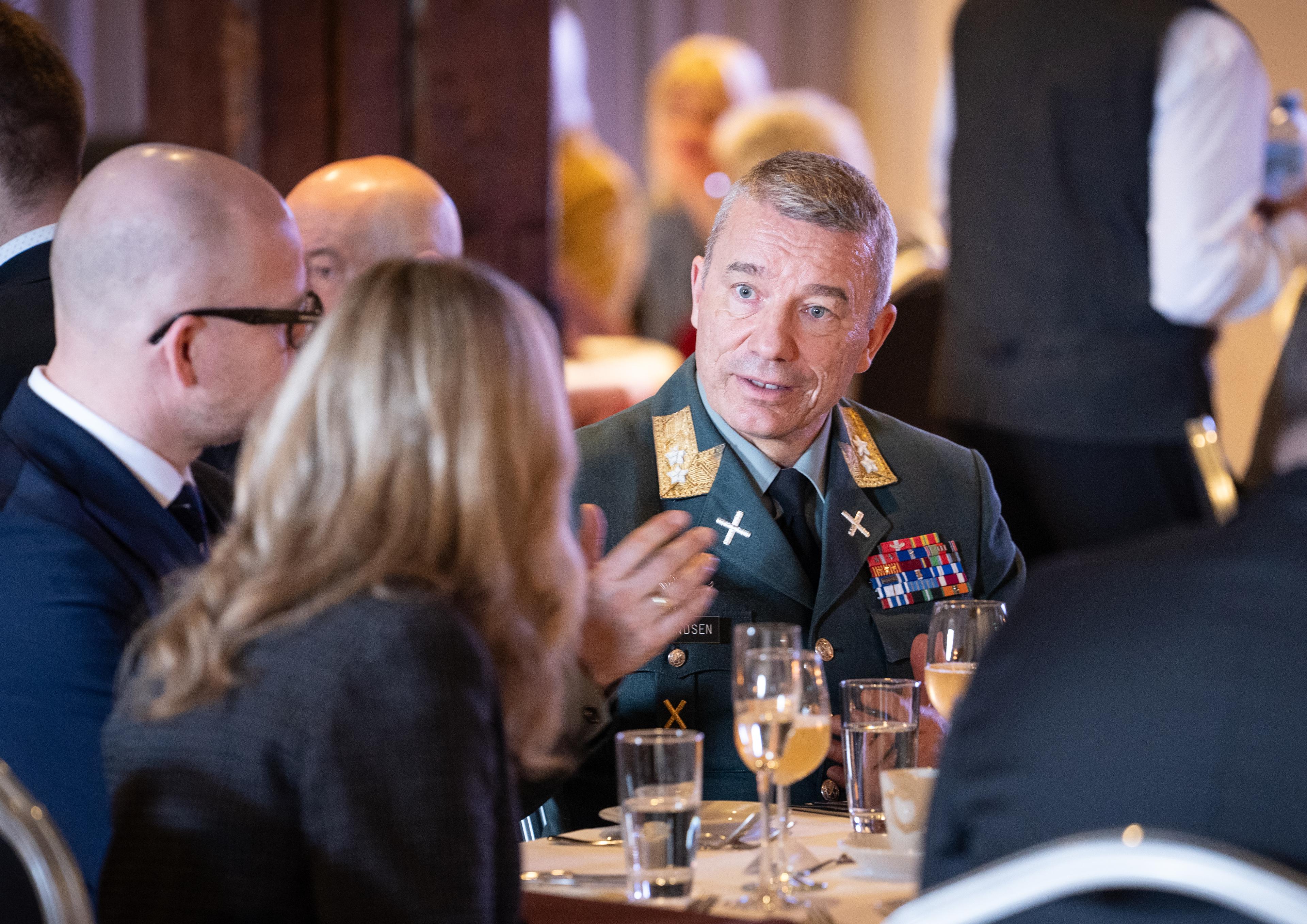 Sjef for Heimvernet i Hærens tenesteuniform sit ved eit bord og snakkar med andre deltakarar.