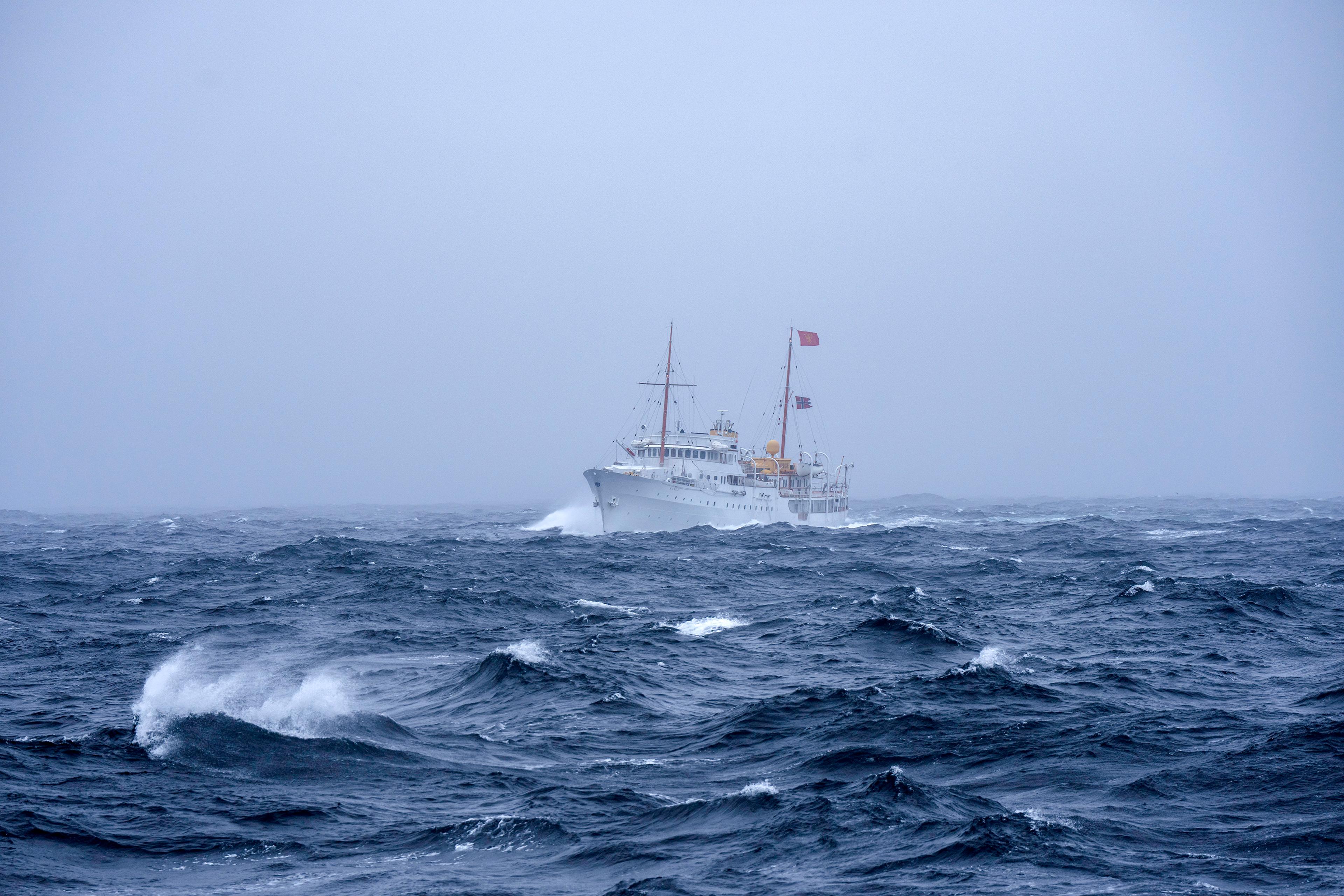 Skipet på vei gjennom dårlig vær med tåke. Bølgene går hvite.