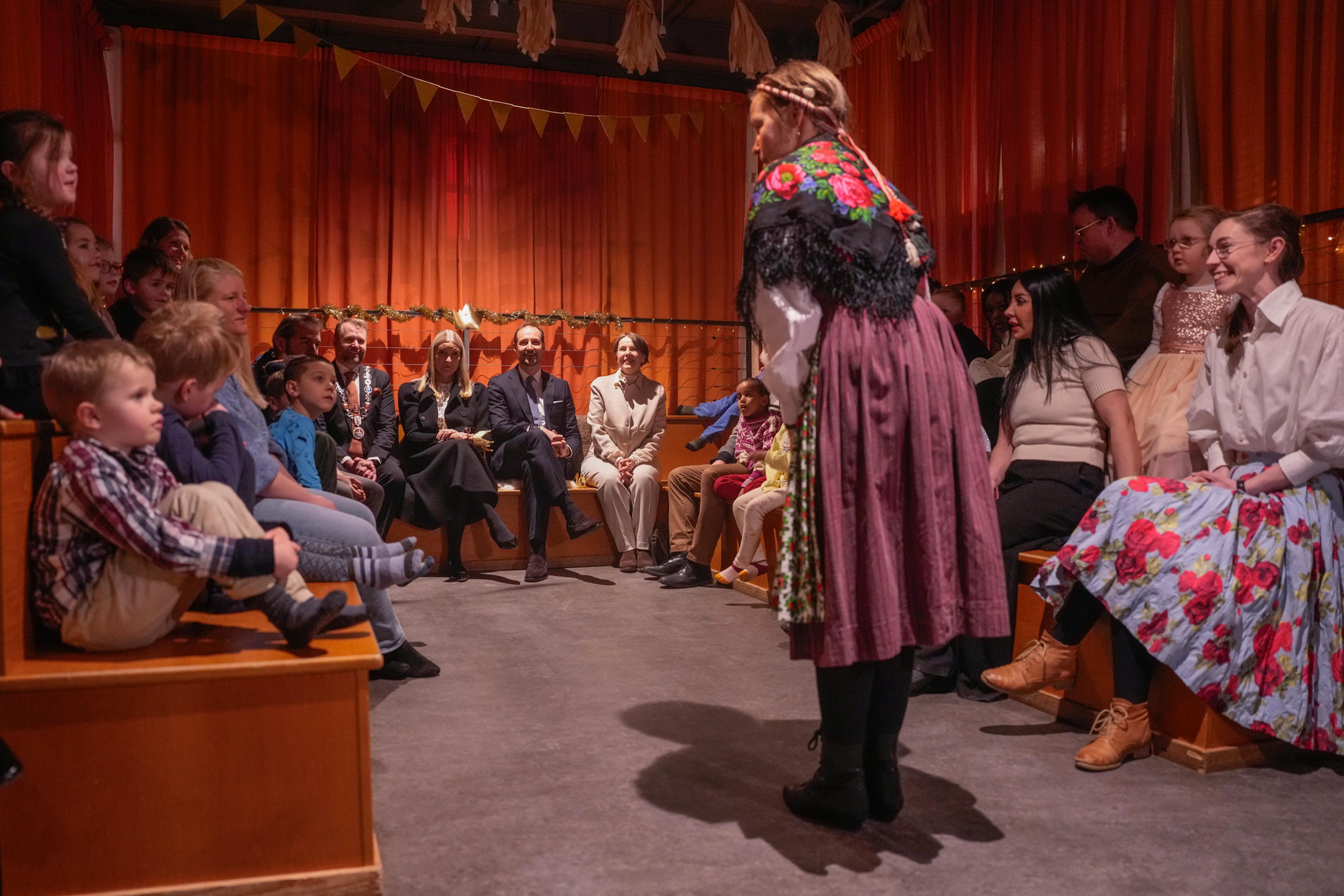 Kronprinsparet sammen med barnehagebarn. Det formidles eventyr