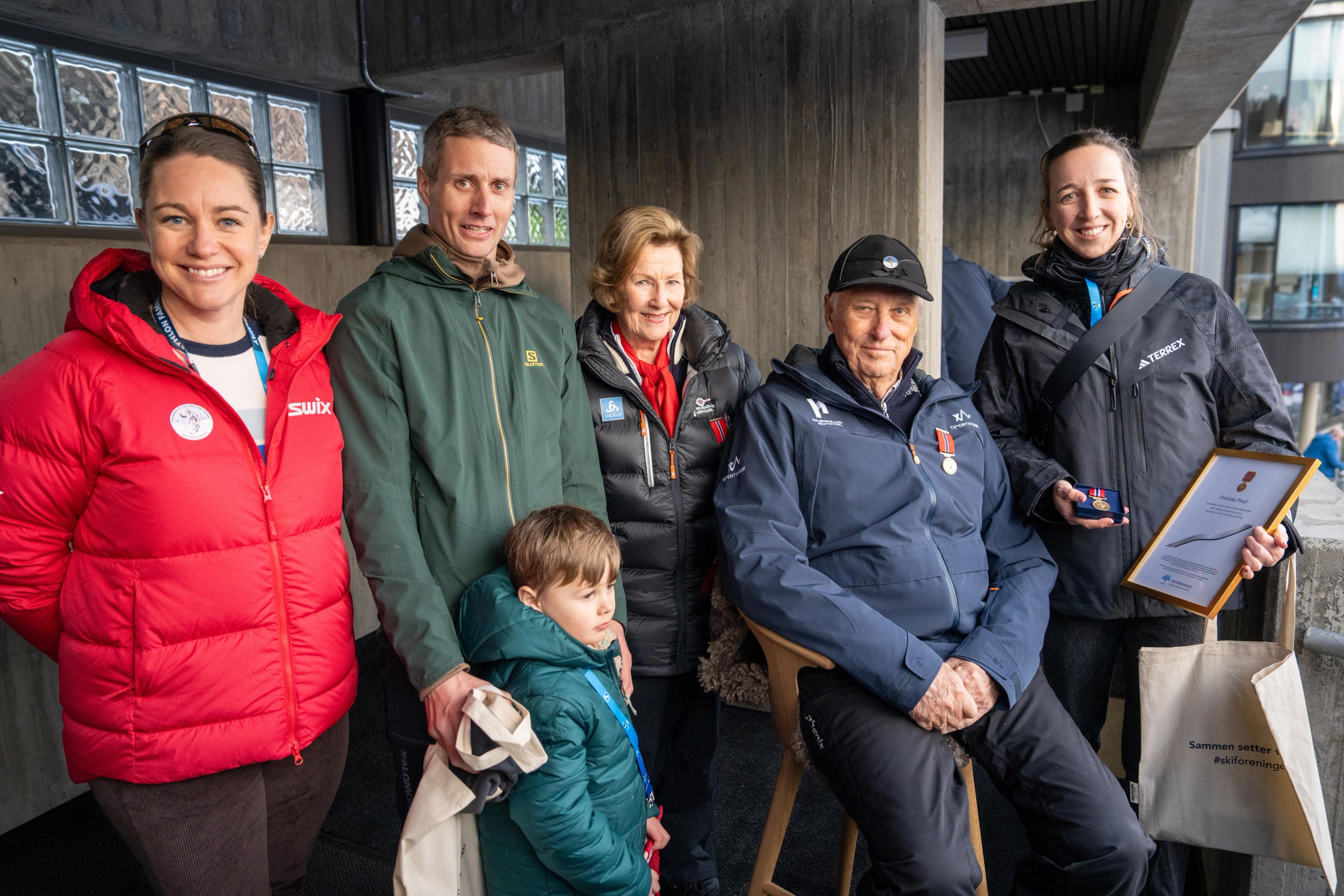 Julie Undlien Wisth i Skiforeningen, Nils-Erik Ulset med sønn, Dronning Sonja, Kong Harald og Franziska Preuss på tribunen i Holmenkollen.