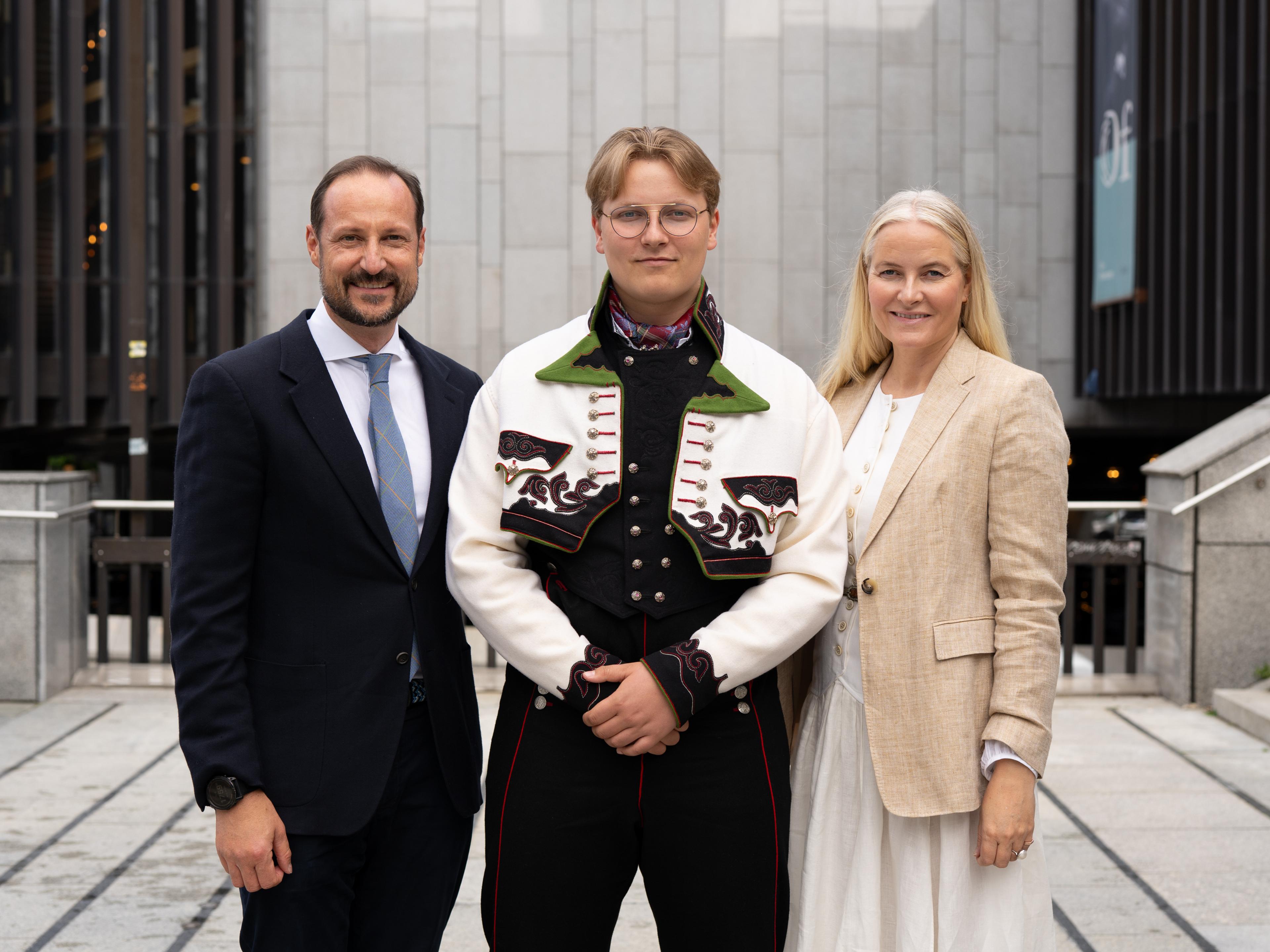 Prins Sverre Magnus står i midten, ikledd sin Øst-telemarkbunad, med foreldrene på hver side.