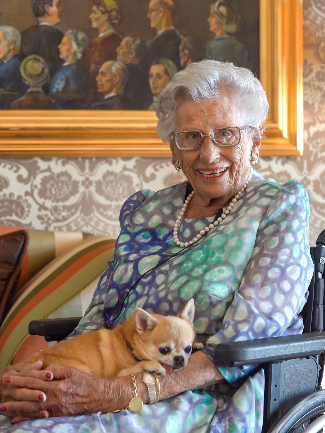 Prinsesse Astrid sitter smilende med hunden sin på fanget.