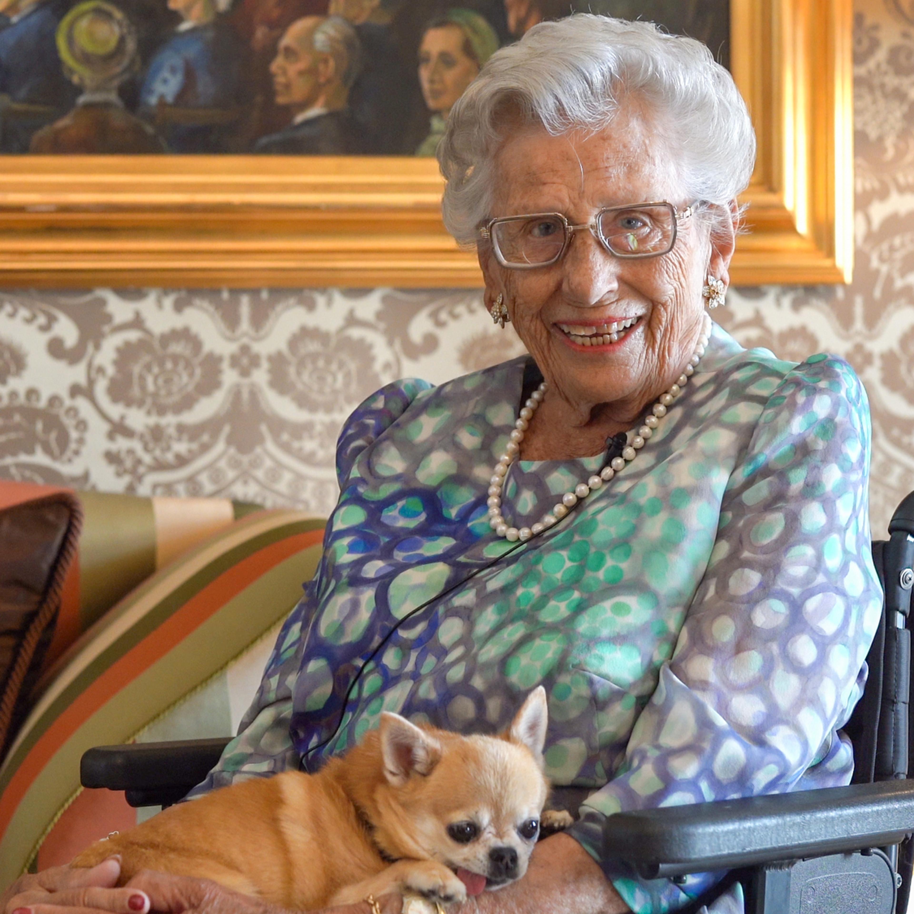 Prinsesse Astrid sitter smilende med hunden sin på fanget.