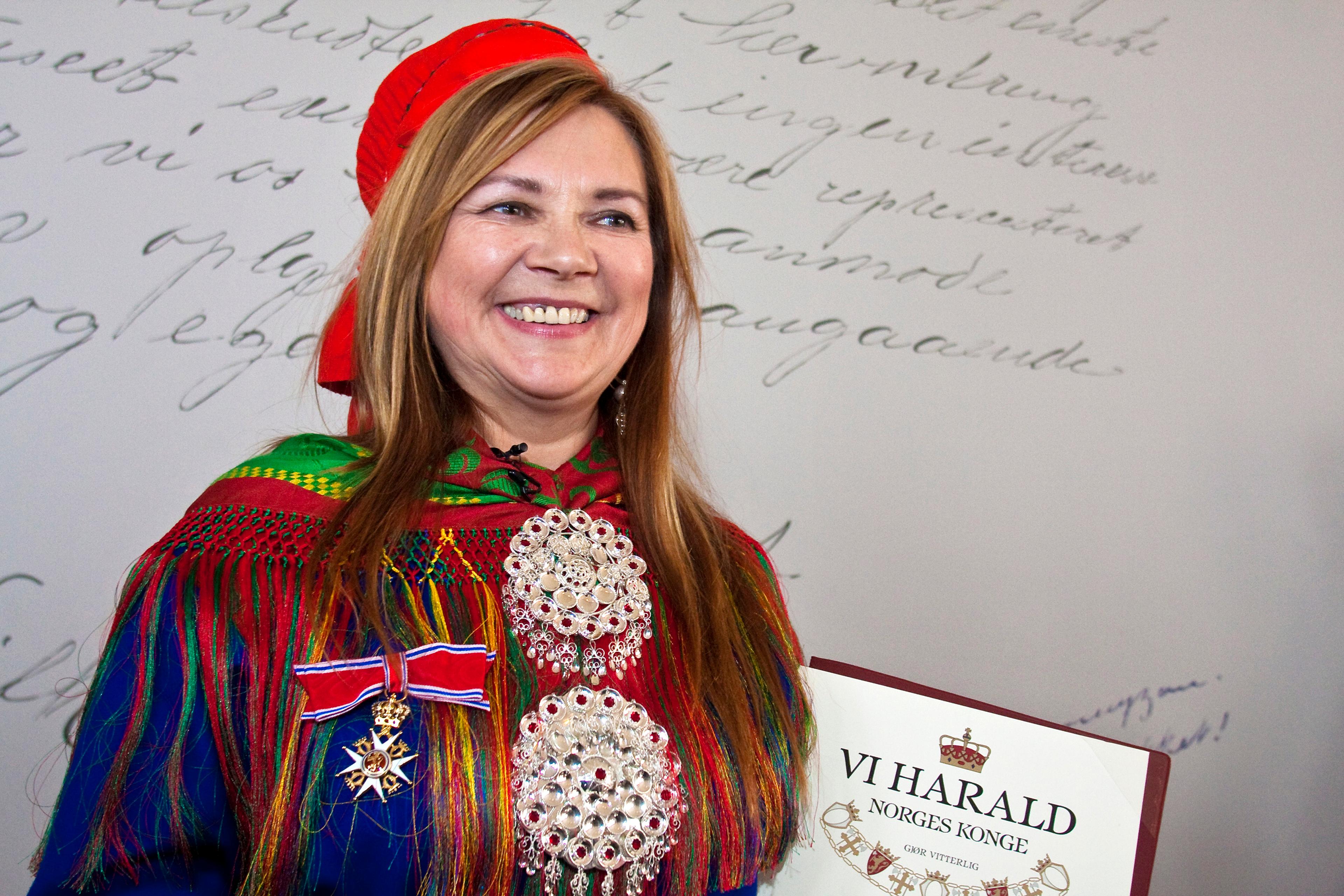 Boine med diplomet i hånden og ordenen festet til samekoften.