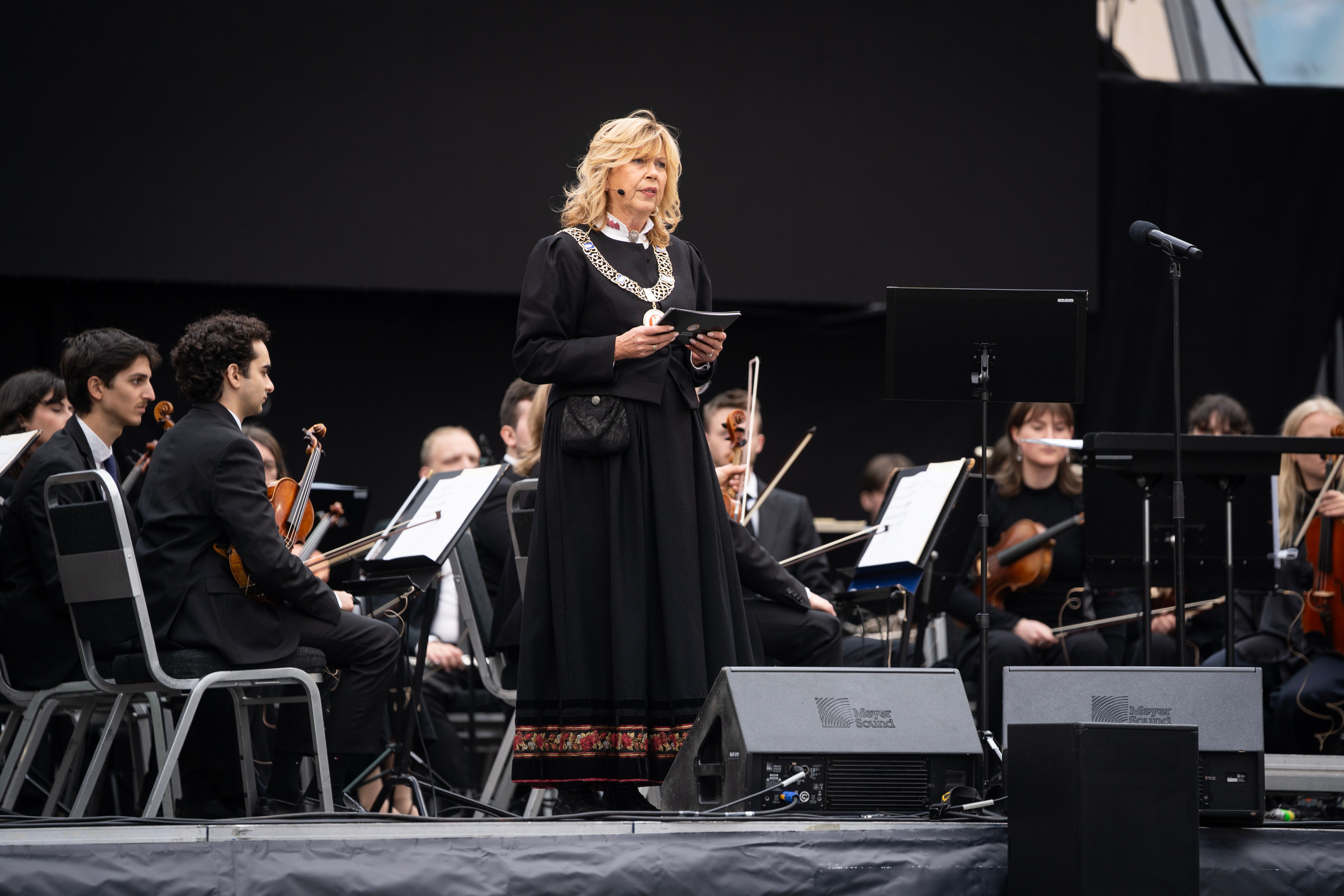 Ordføreren på scenen med bunad og ordførerkjede