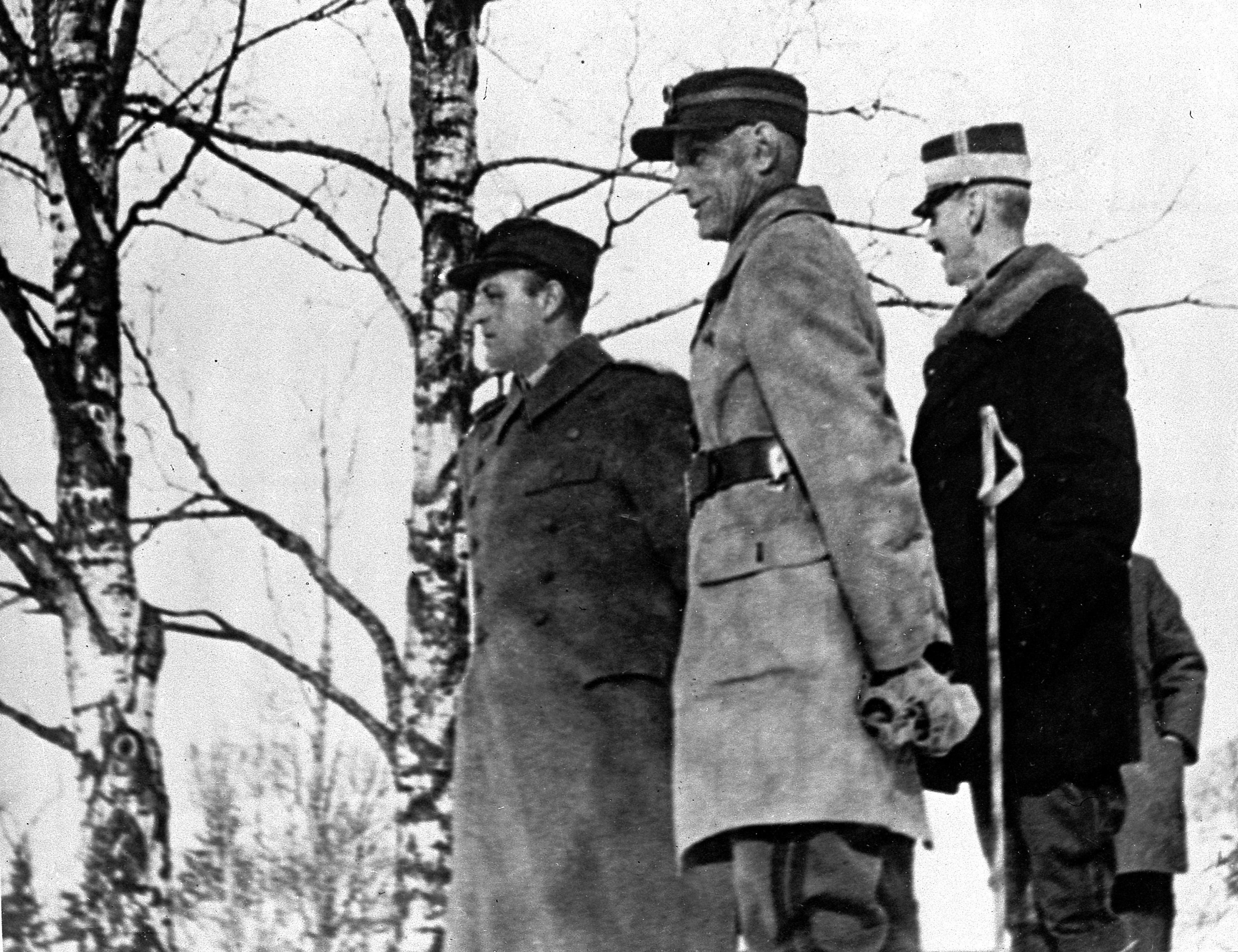 Alle tre står i feltuniform ute i et snølandskap med bare bjerketrær.