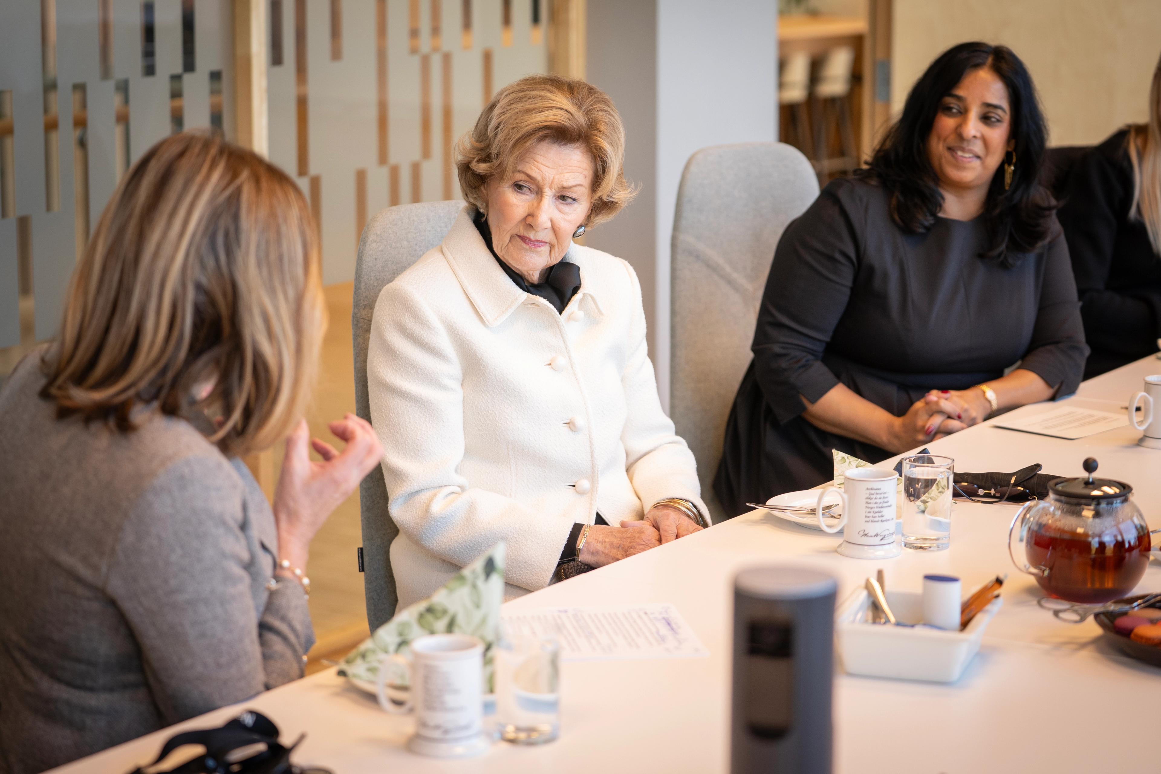 Dronning Sonja og statsråd Lubna Jaffrey ser på Inga Bolstad under orienteringen.