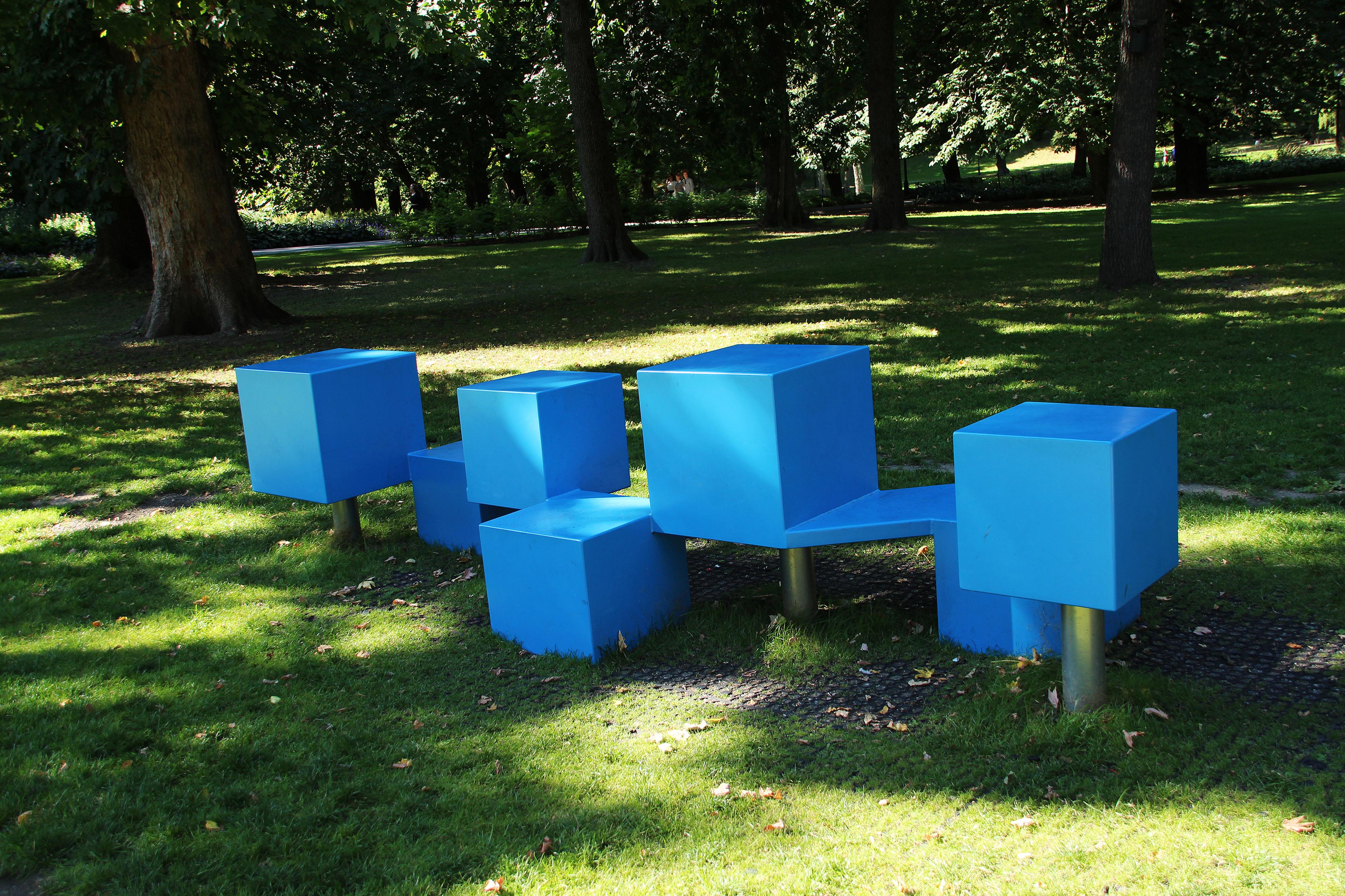 En benk laget av blå kvadrater. Fire lave og fire litt høyere.