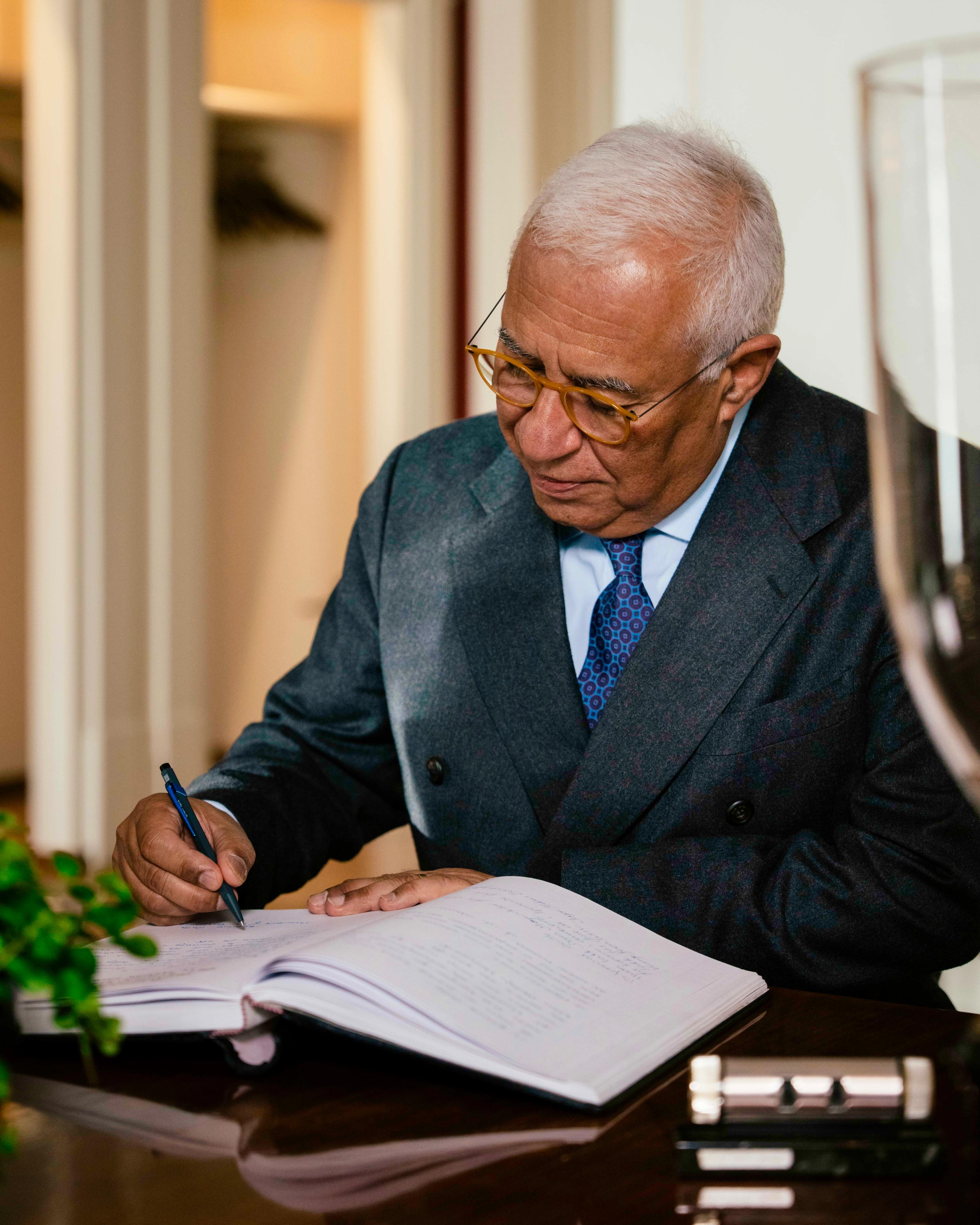 António Costa sit ved eit skrivebord og signerer gjesteboka.
