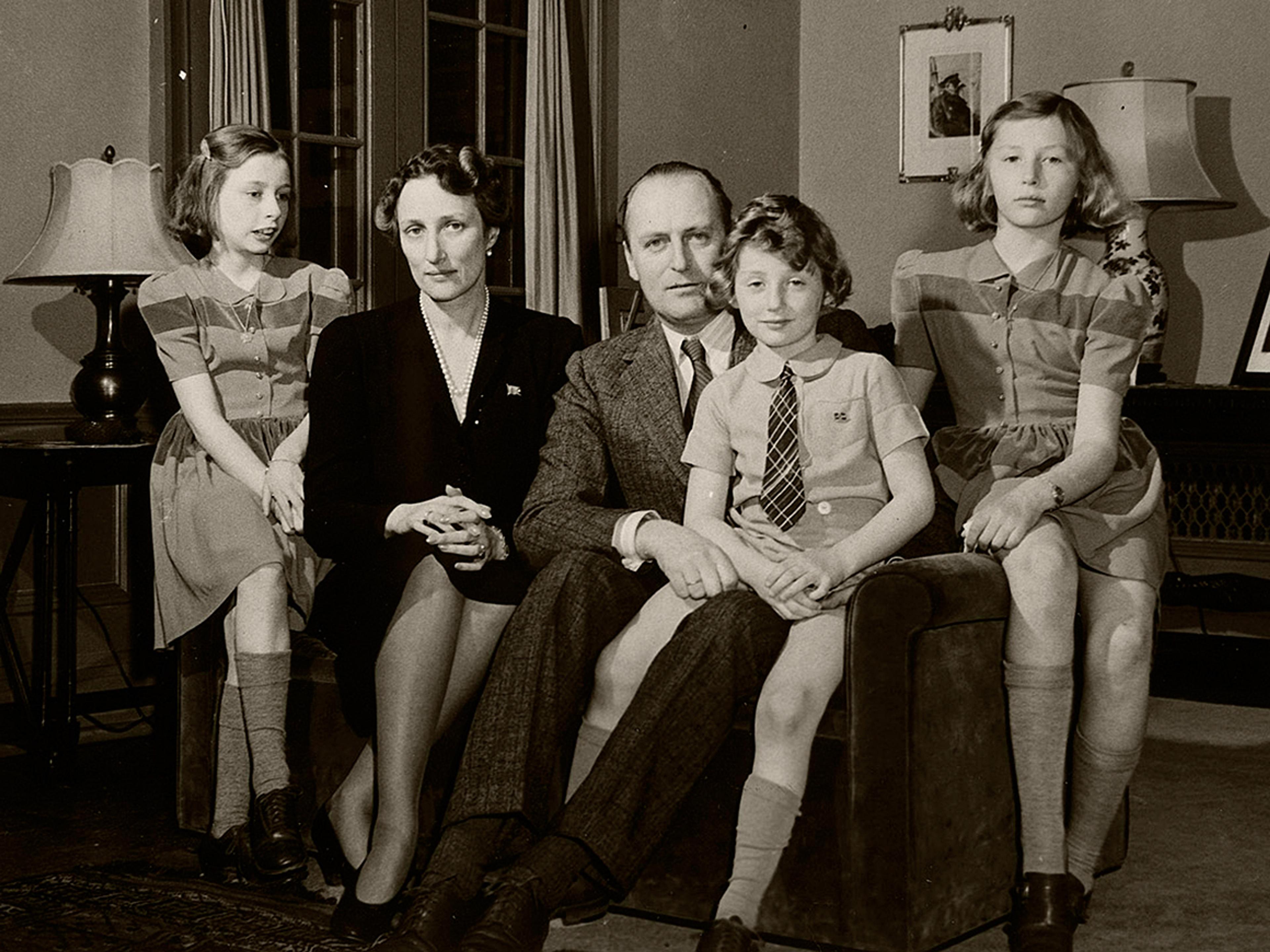 Familien sitter samlet i en sofa. Prins Harald sitter på fanget til sin far, Kong Olav.