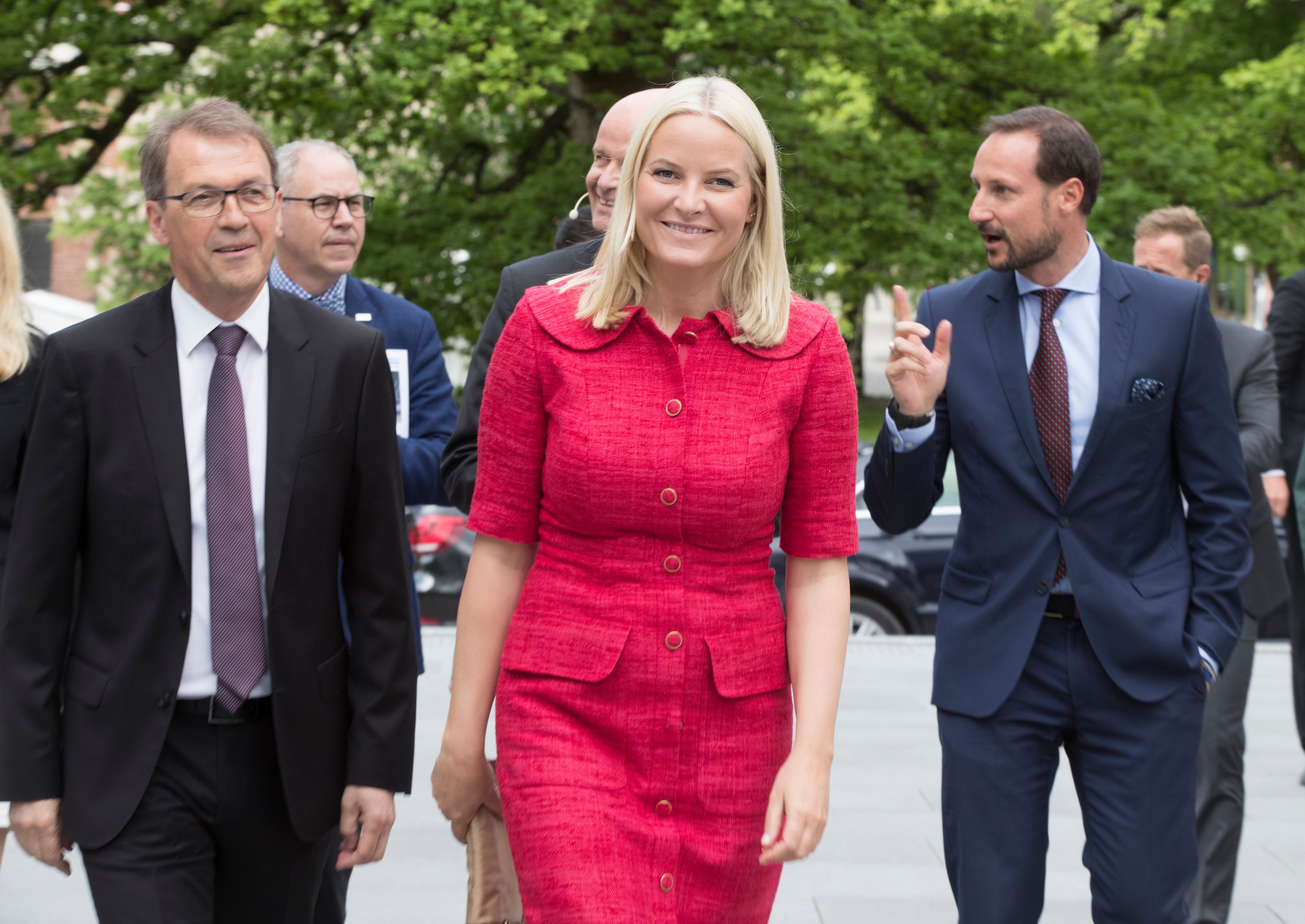 Kronprinsparet kommer gående - Kronprinsessen foran i rød kjole.