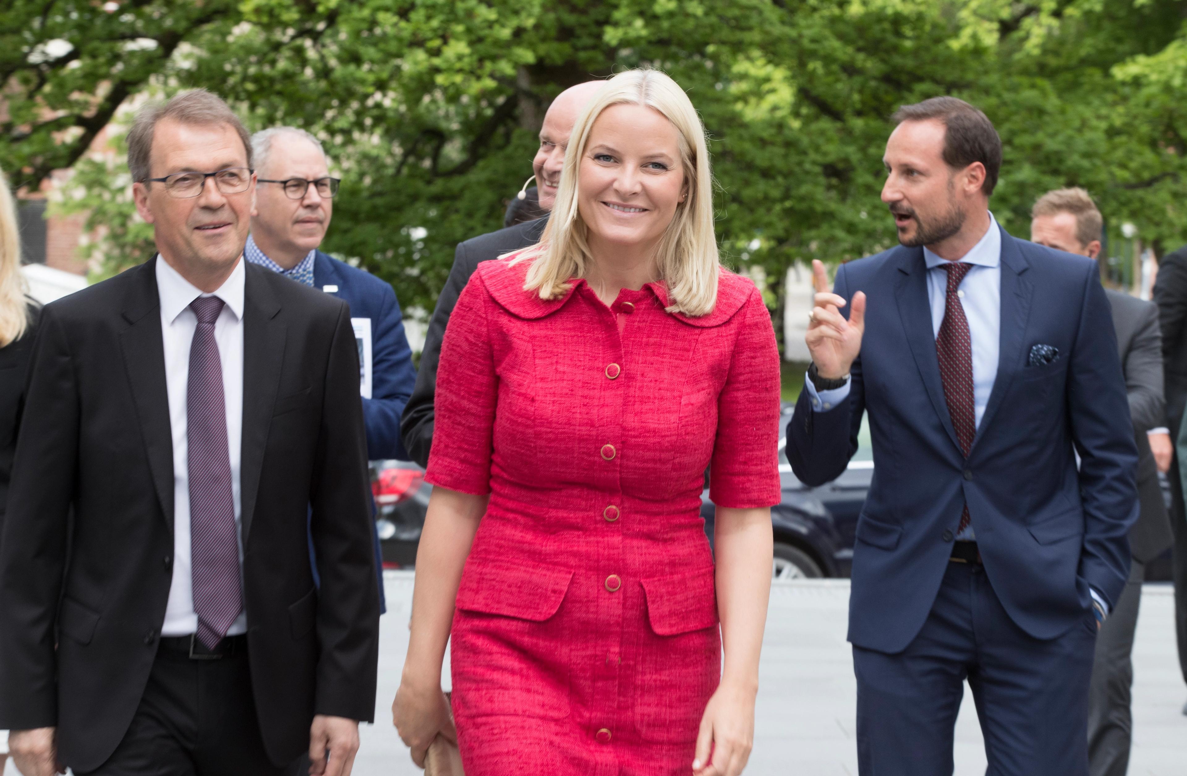 Kronprinsparet kommer gående - Kronprinsessen foran i rød kjole.