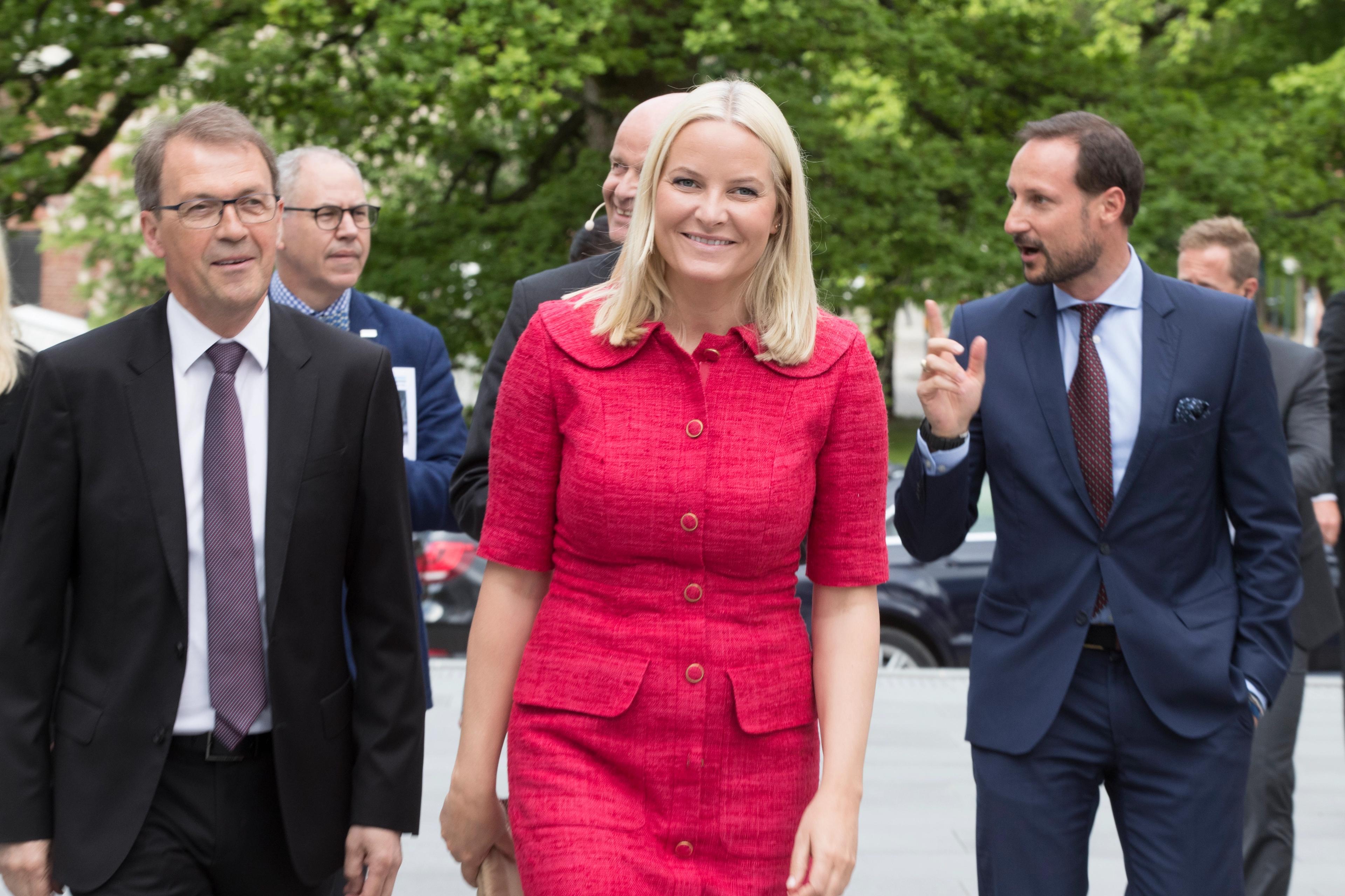 Kronprinsparet kommer gående - Kronprinsessen foran i rød kjole.
