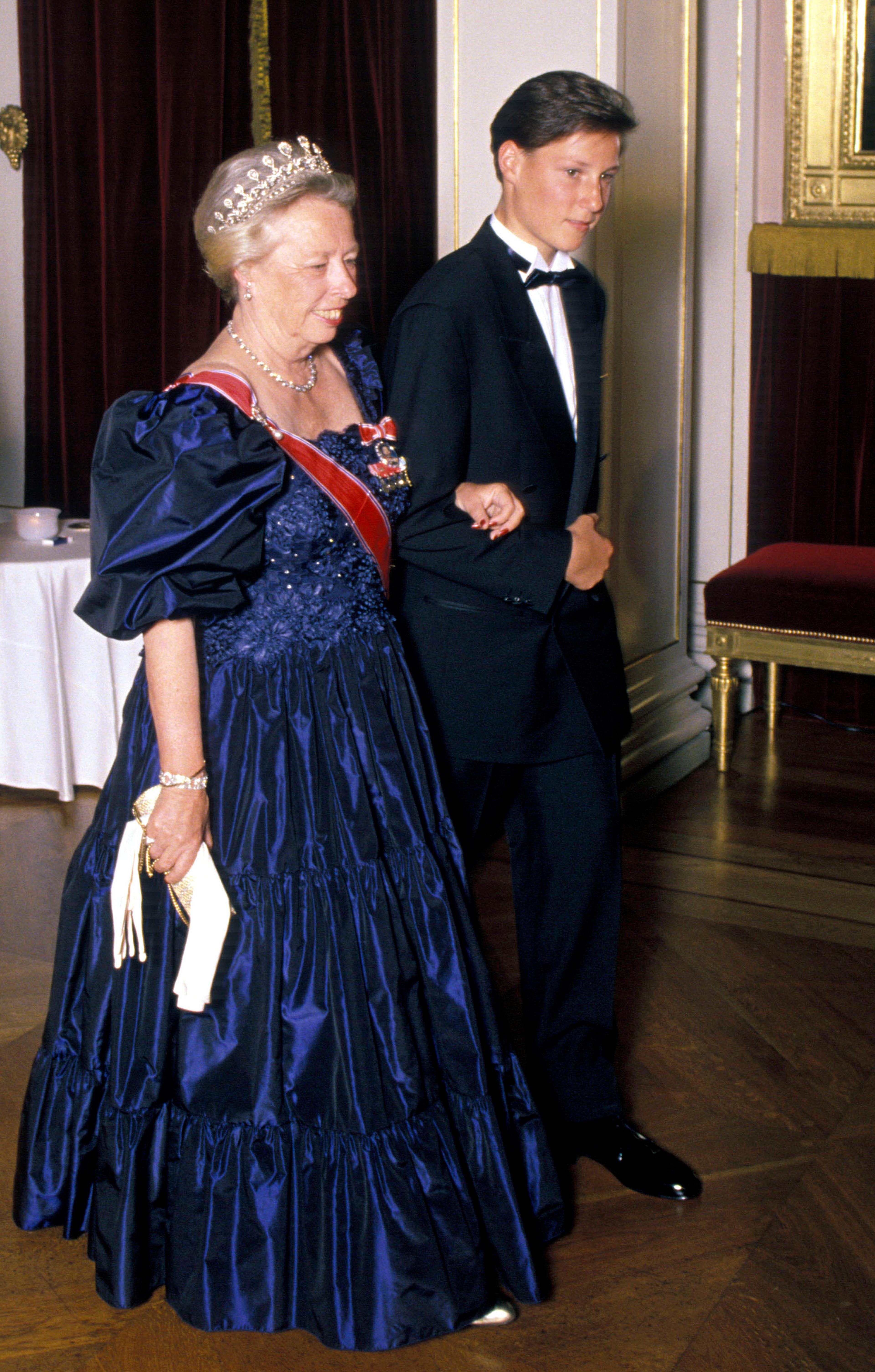 Prinsesse Ragnhild kommer i dypblå gallakjole med ordensbånd og diadem, mens daværende prins Haakon er i mørk dress.