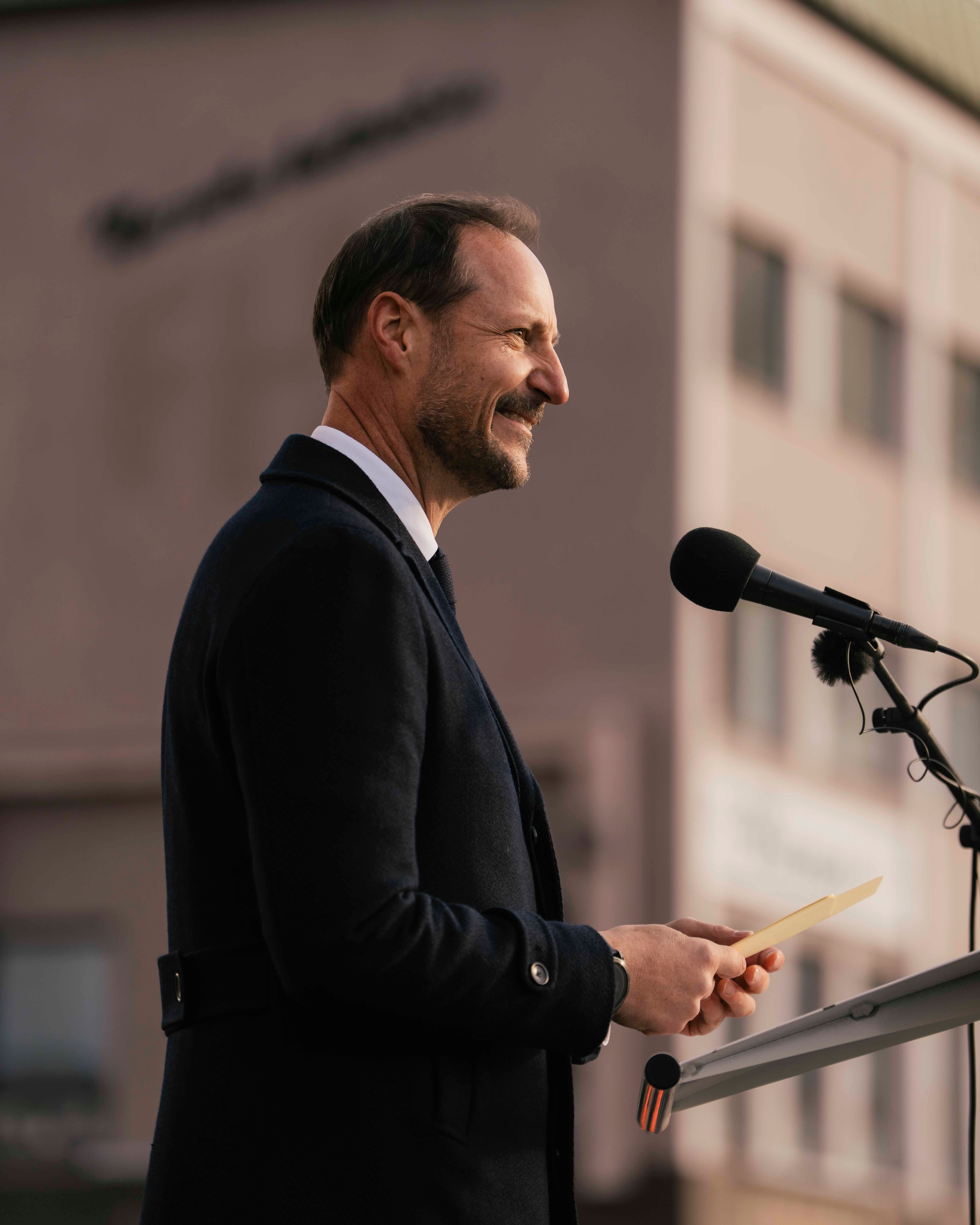 Kong Haakon tå talerstolen. Foran er det festet løv i høstfager og en stor sløyfe i norske farger.