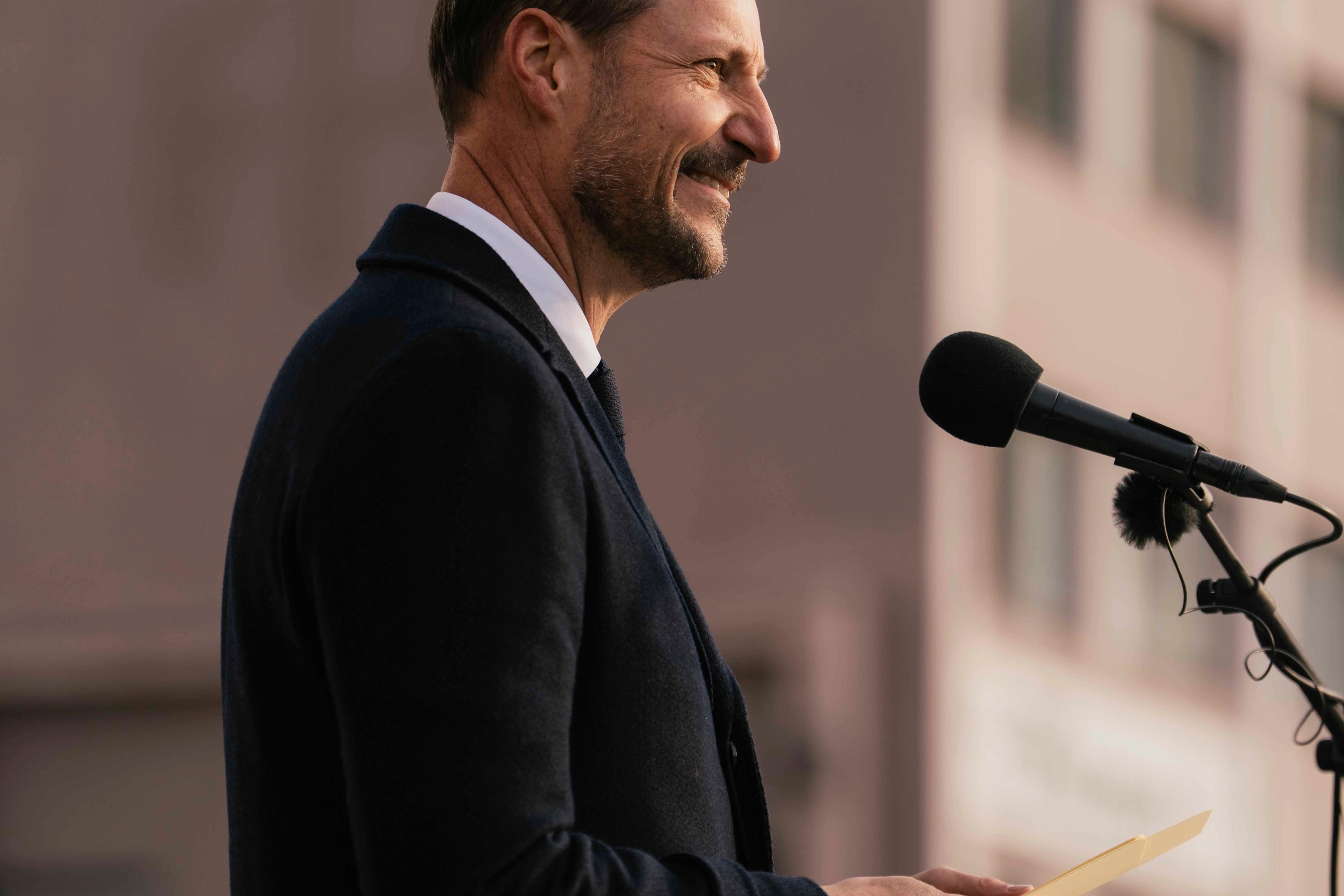 Kong Haakon tå talerstolen. Foran er det festet løv i høstfager og en stor sløyfe i norske farger.