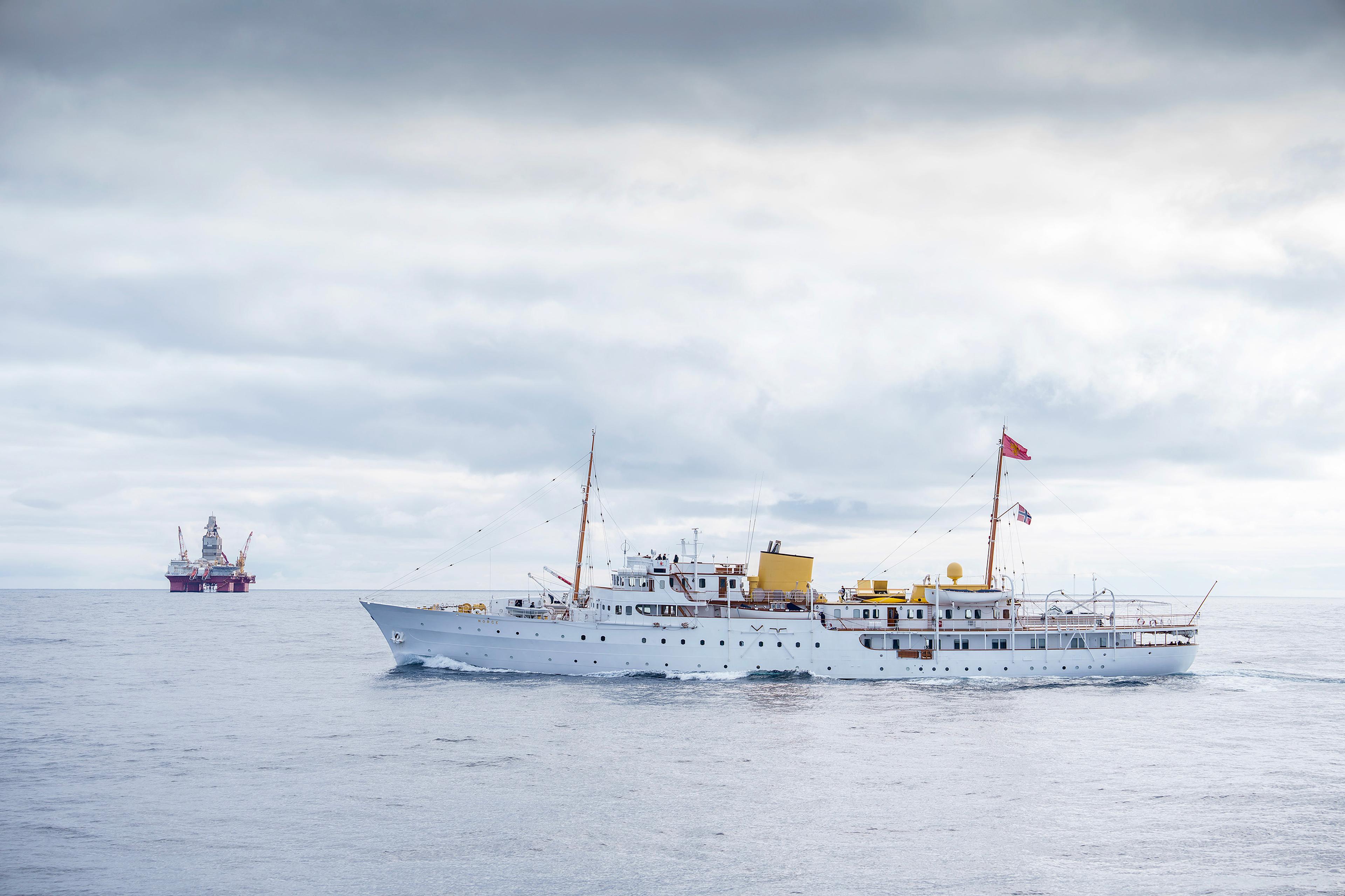 Kongeskipet i forgrunnen passerer en oljeplattform.