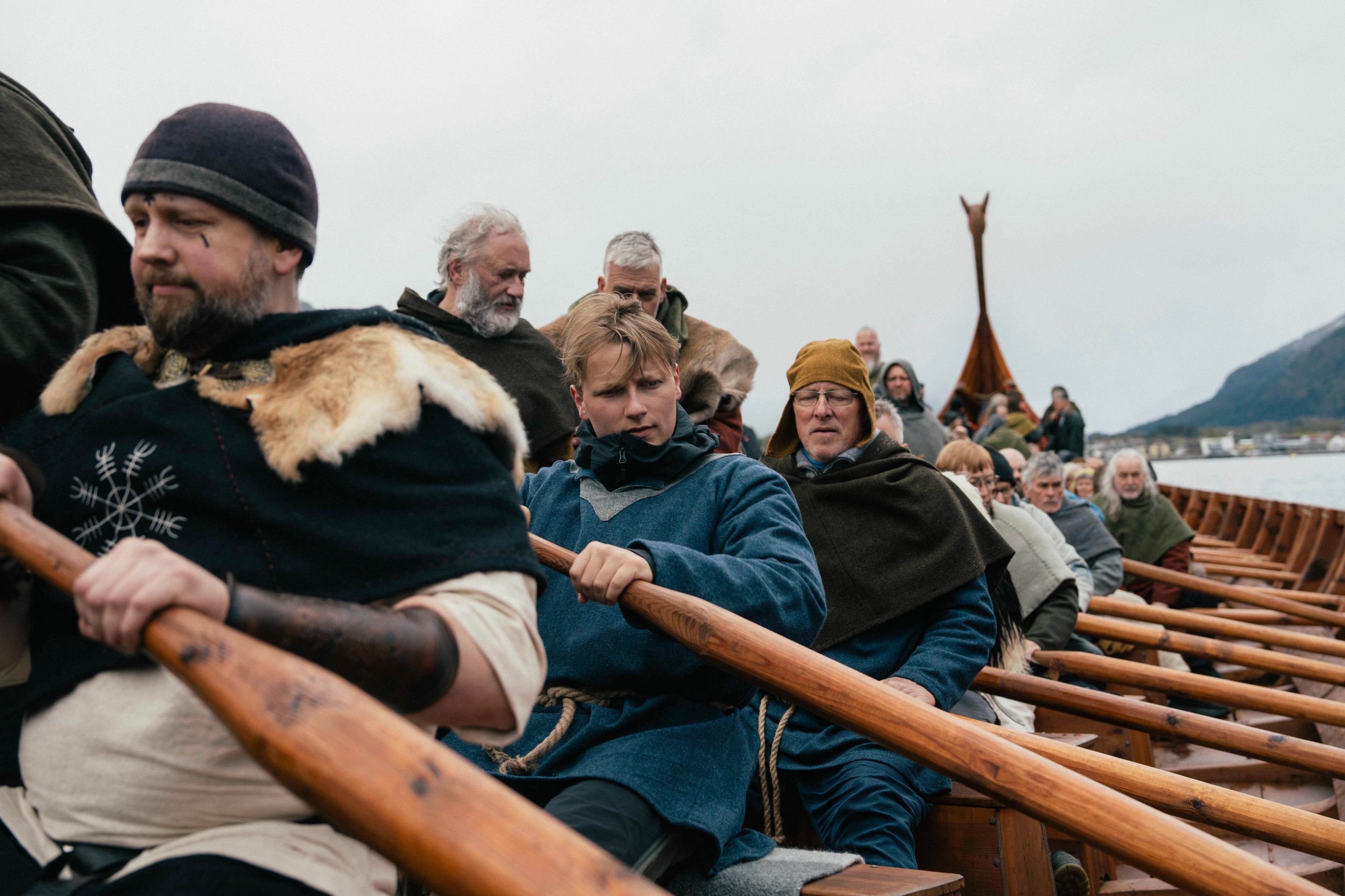 Prins Sverre Magnus sitter i rekonstruksjonen av Myklebustskipet og ror på rekke med flere andre som er kledd i vikingklær.