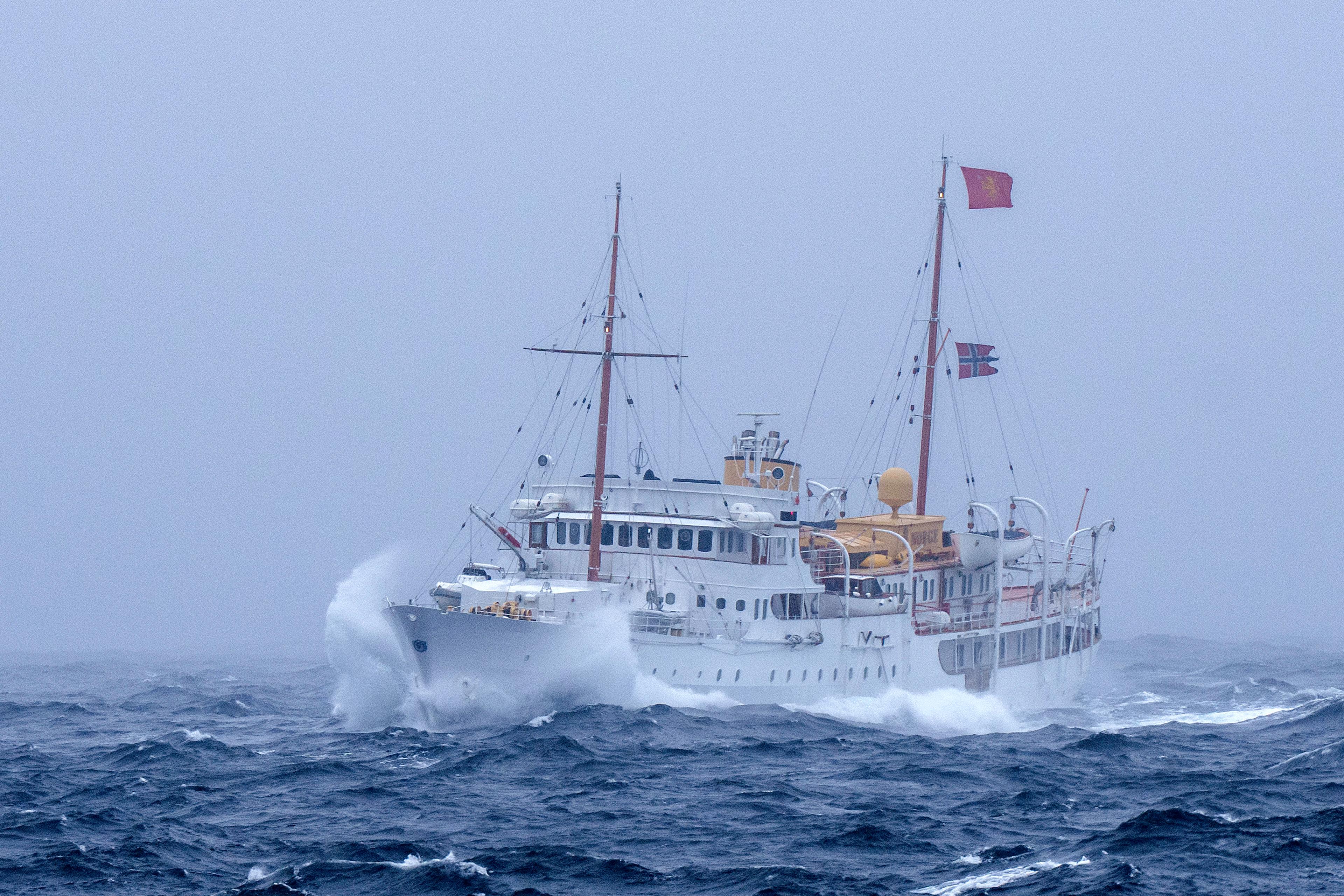 Kongeskipet på vei gjennom dårlig vær med tåke. Bølgene går hvite.