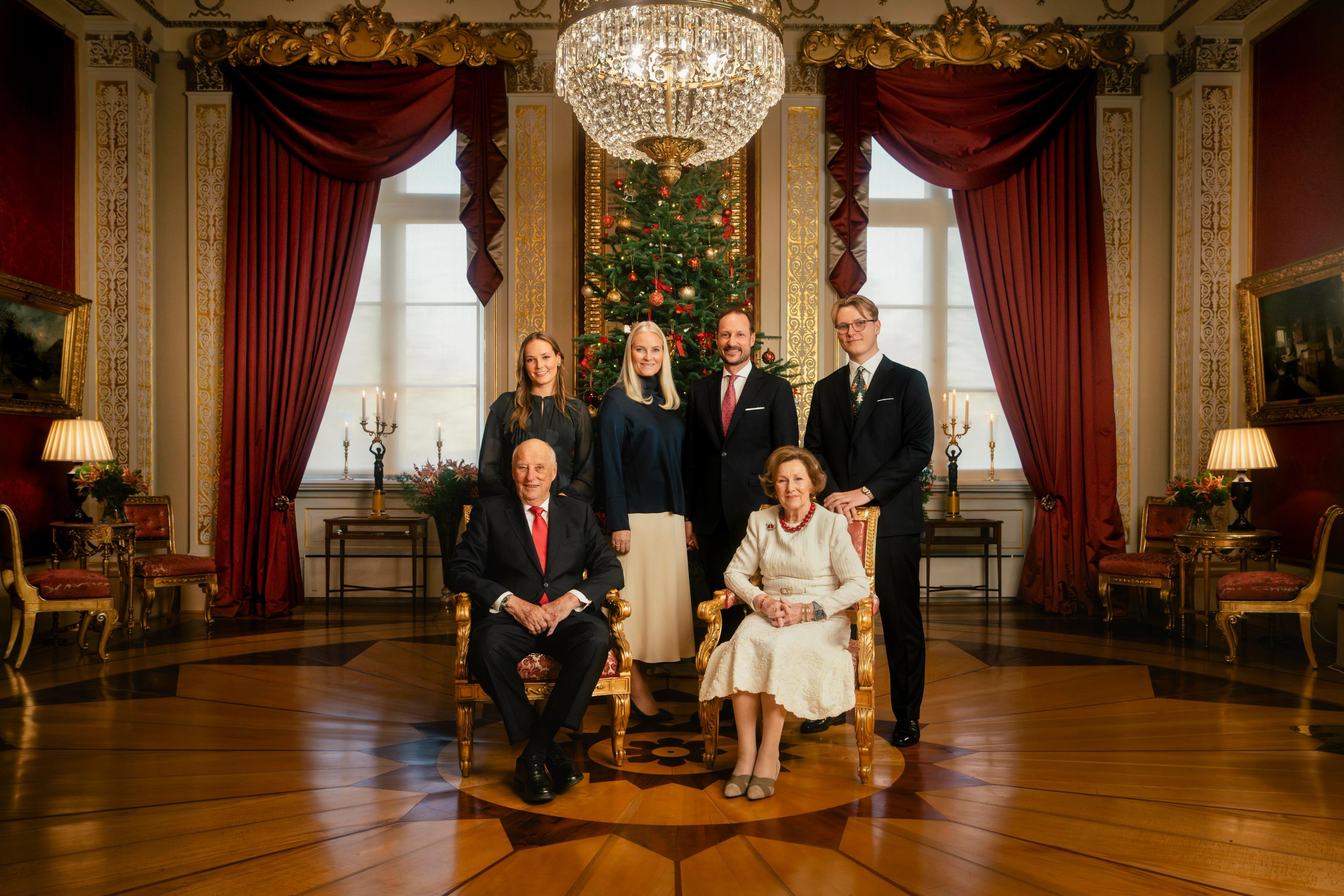 Kongeparet, Kronprinsparet, Prinsesse Ingrid Alexandra og Prins Sverre Magnus samlet i en julepyntet Røde salong.
