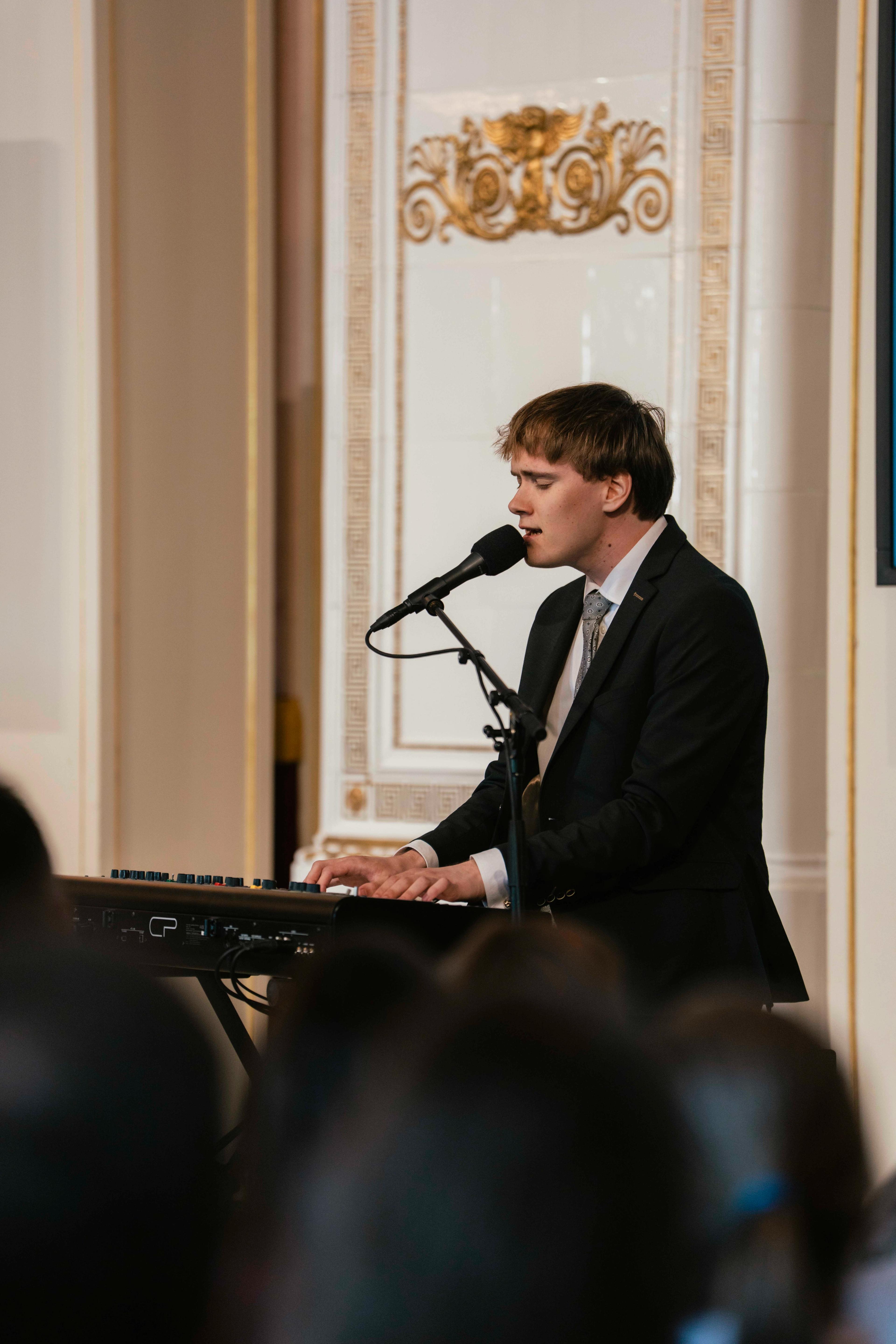 Saxegaard sitter ved et keyboard og synger.