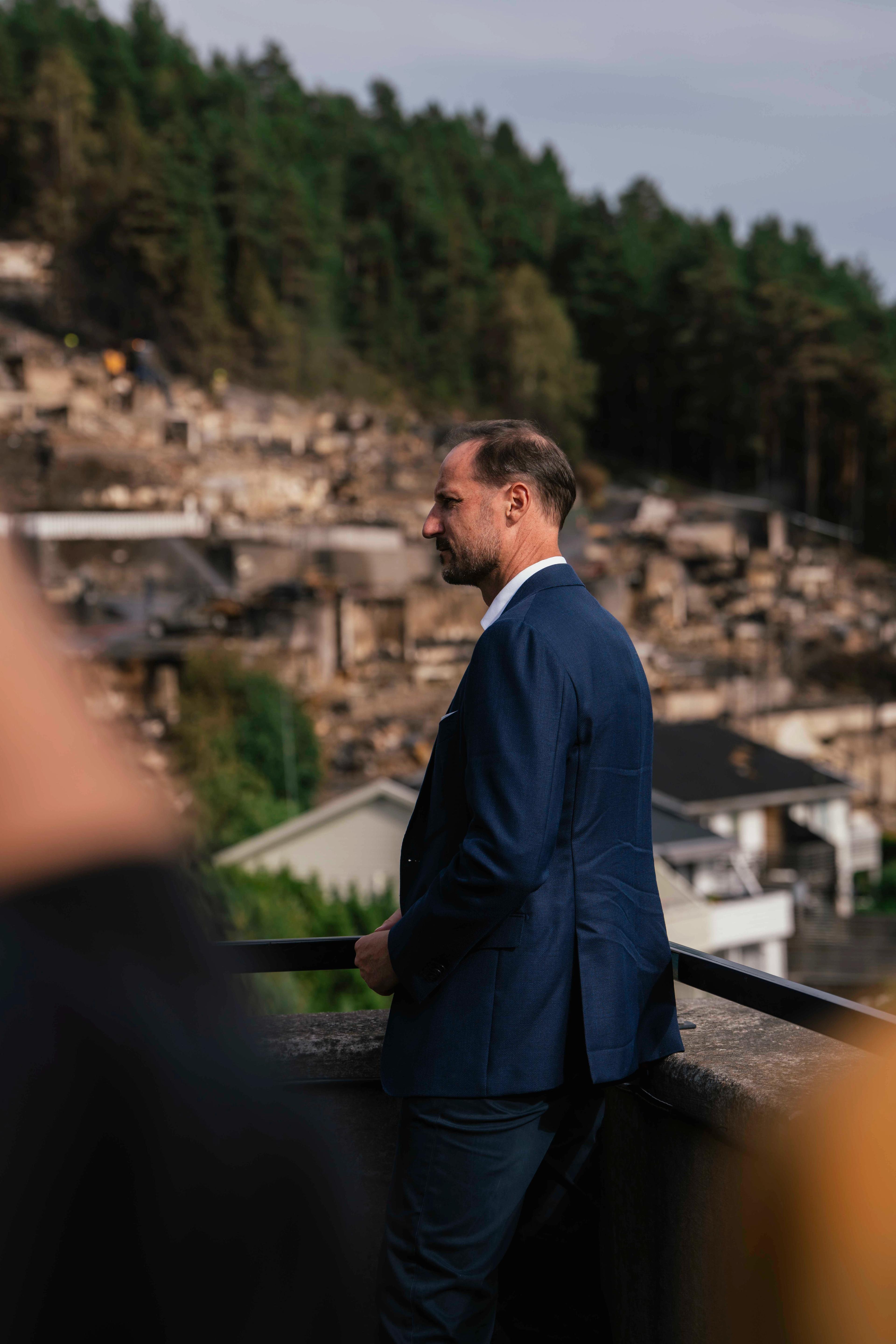 Kronprins Haakon ser på brannruinene i Krokstadelva