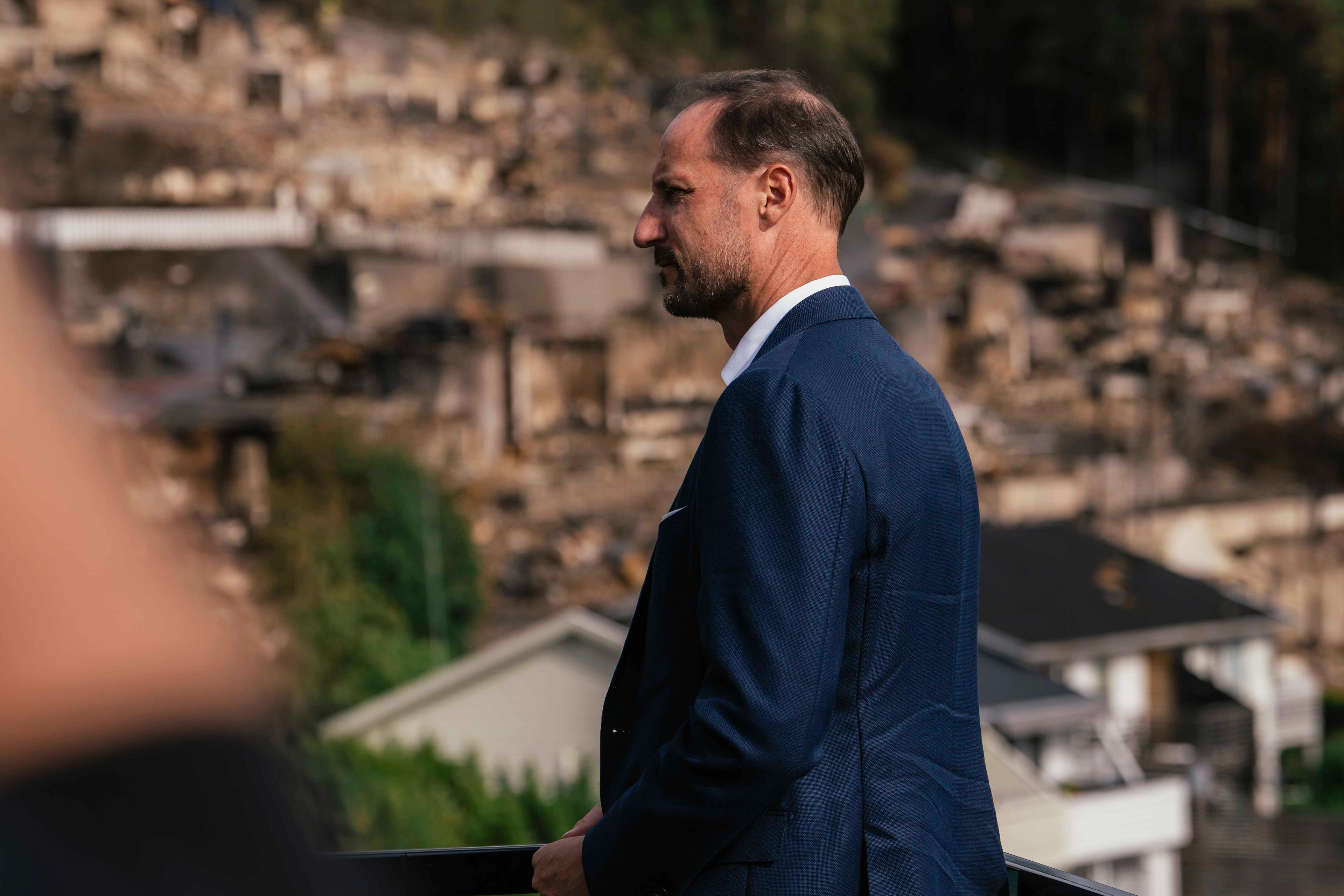 Kronprins Haakon ser på brannruinene i Krokstadelva