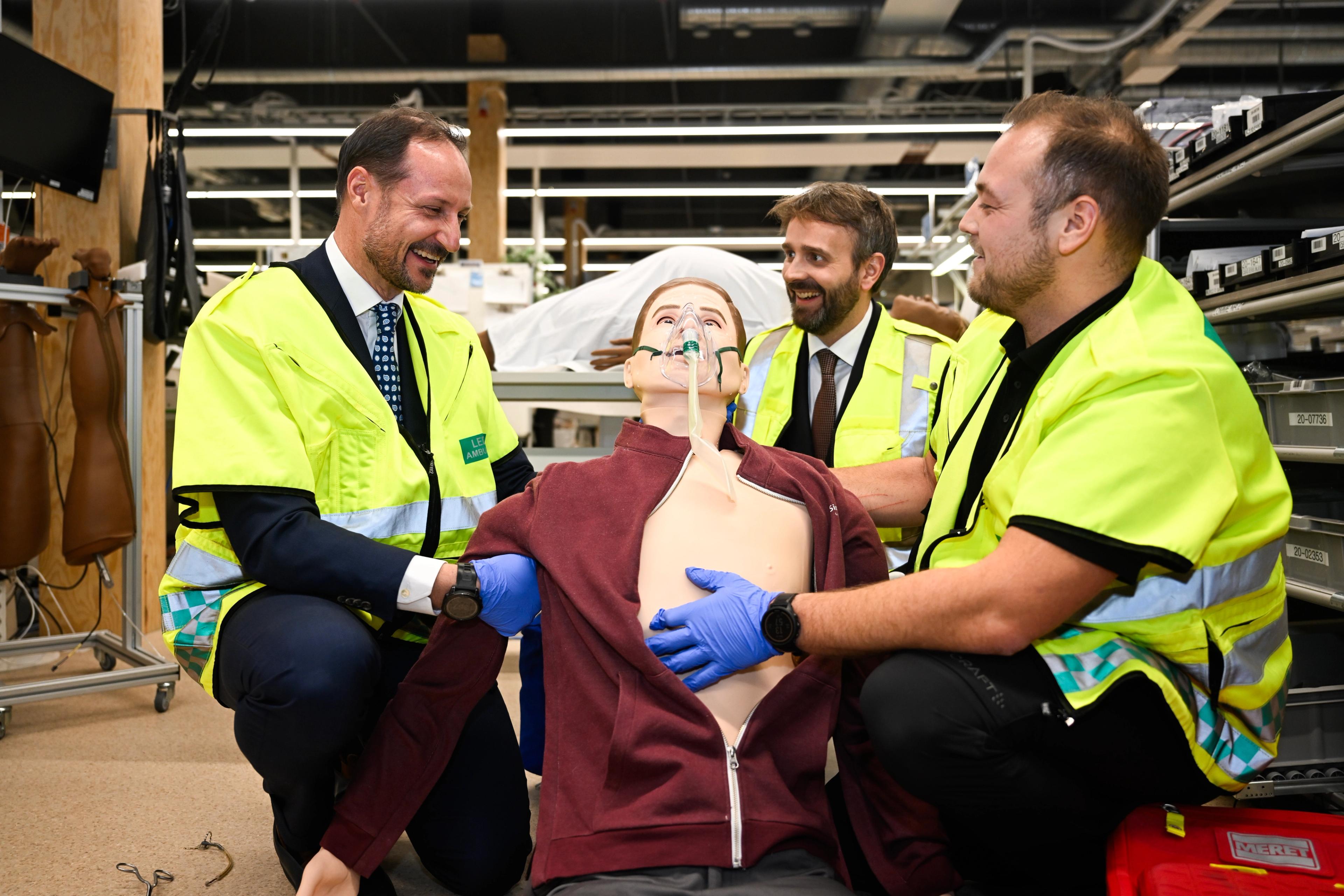 Kronprins Haakon og Jan Christian Vestre sammen med en medisinsk simuleringsdukke.