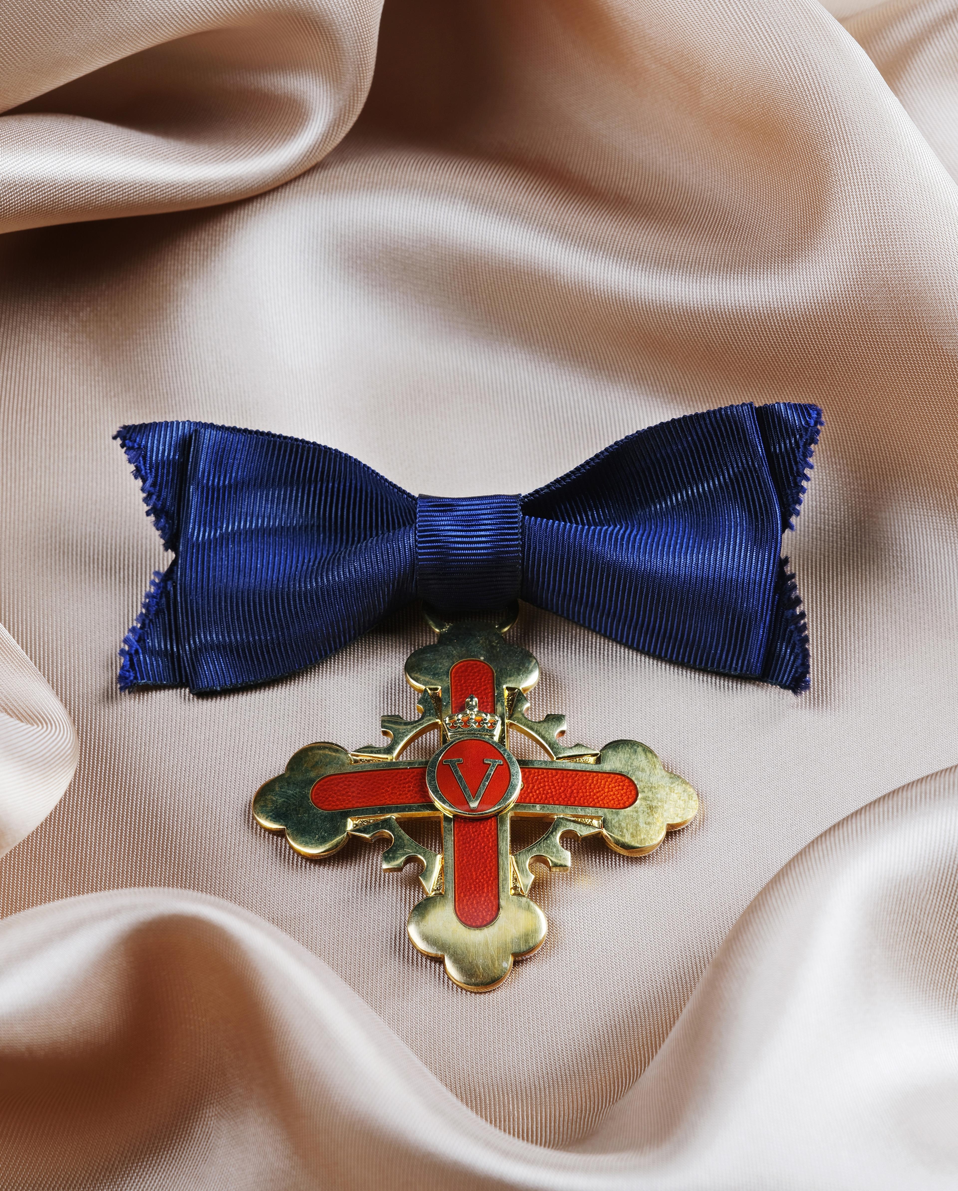 Forjenstordenens ridderkors i gull og og rød emalje festet i en dypblå sløyfe.