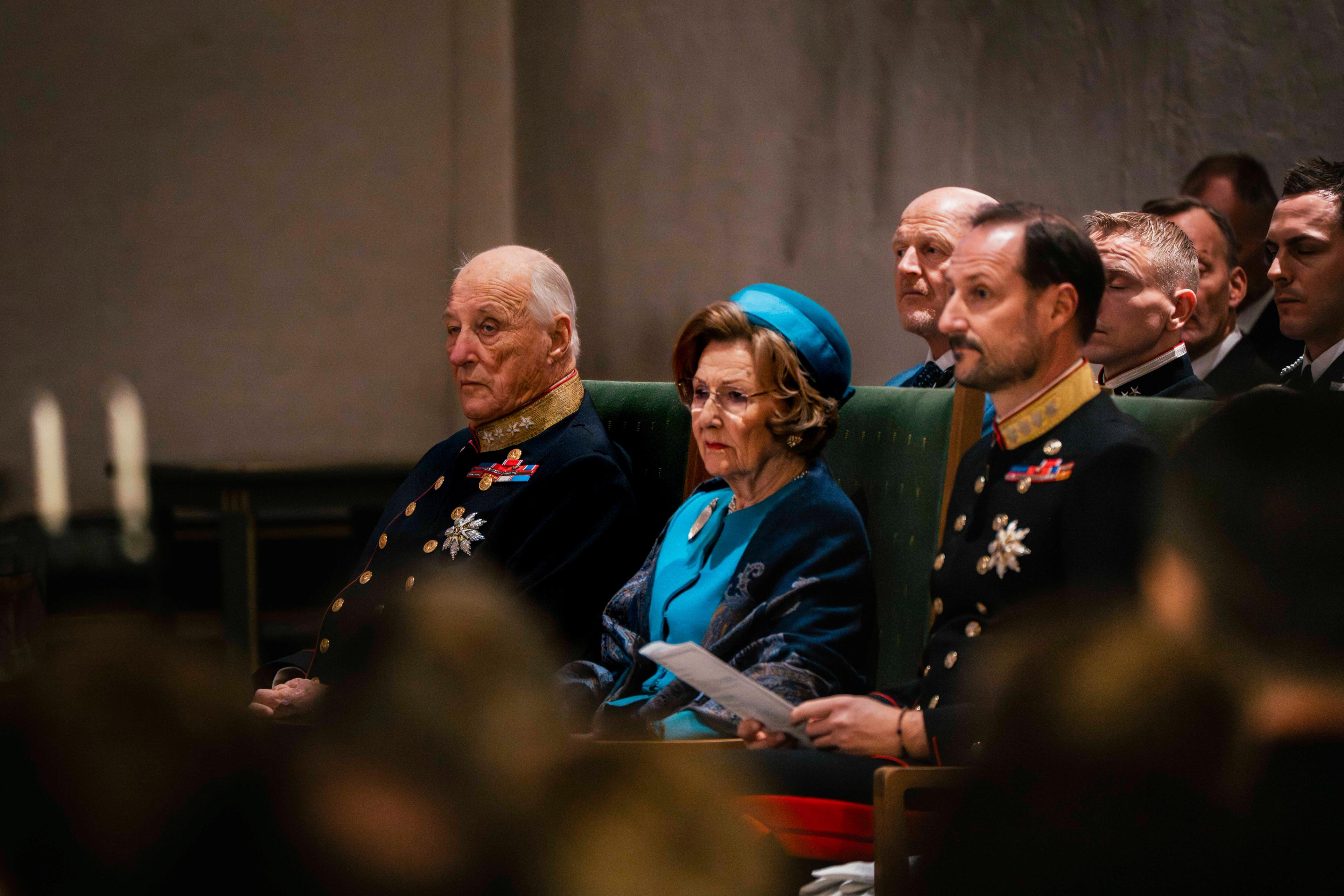 Kong Harald, Dronning Sonja og Kronprins Haakon sitjande.