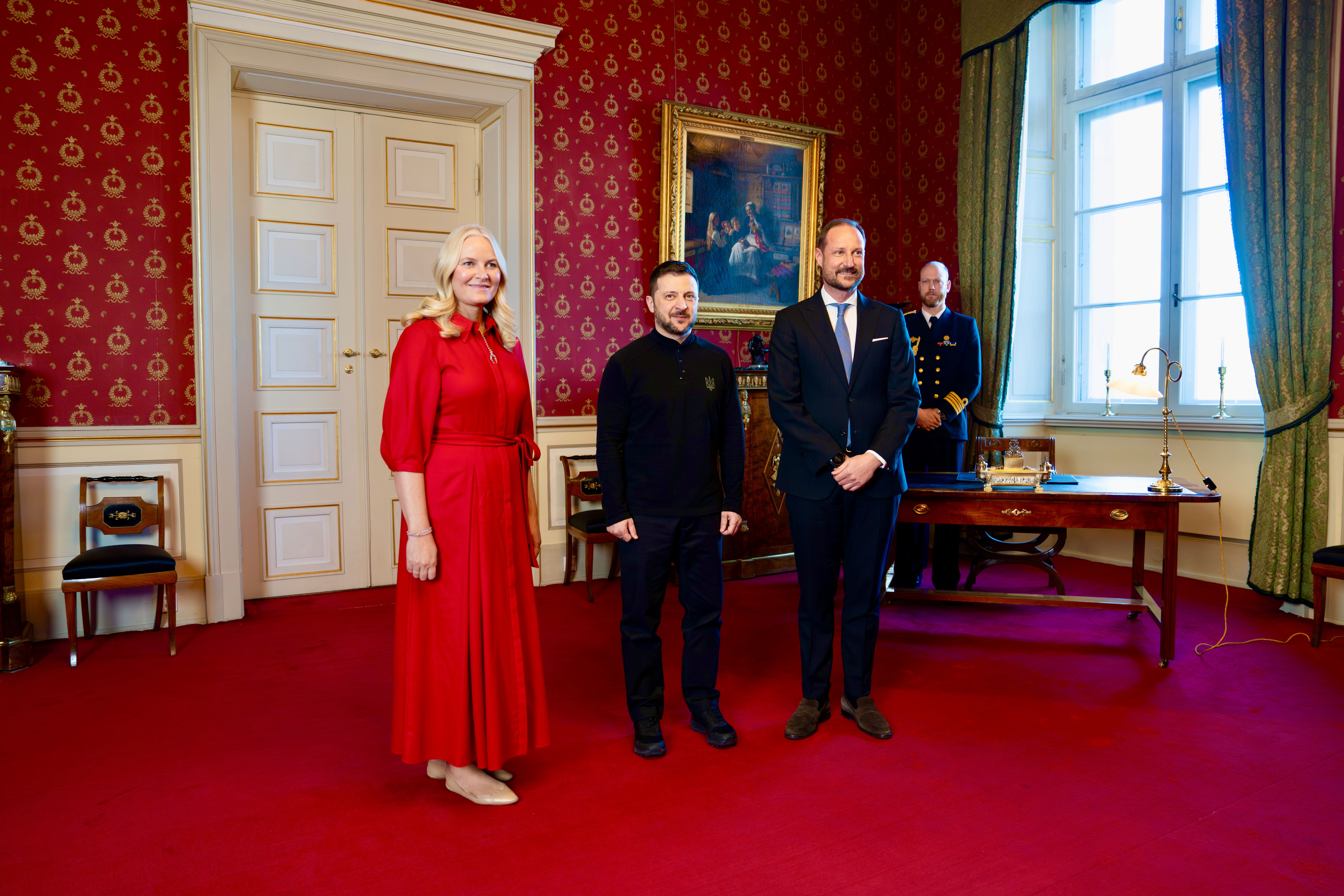 President Zelenskyj står mellom Kronprinsen og Kronprinsessen for offisiell fotografering.