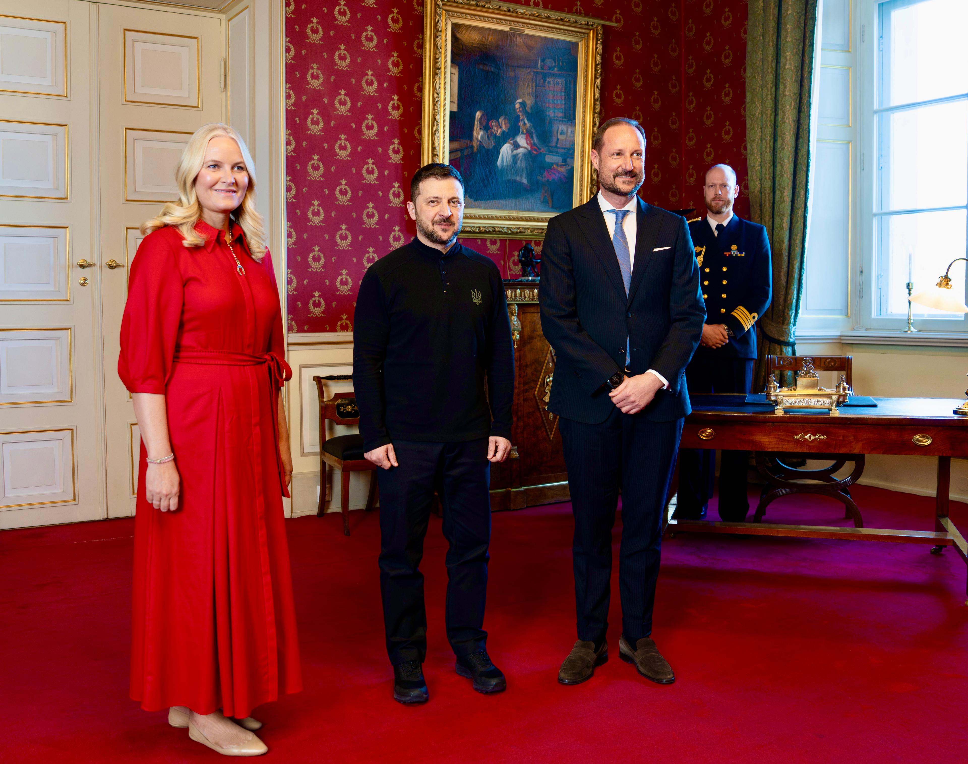 President Zelenskyj står mellom Kronprinsen og Kronprinsessen for offisiell fotografering.