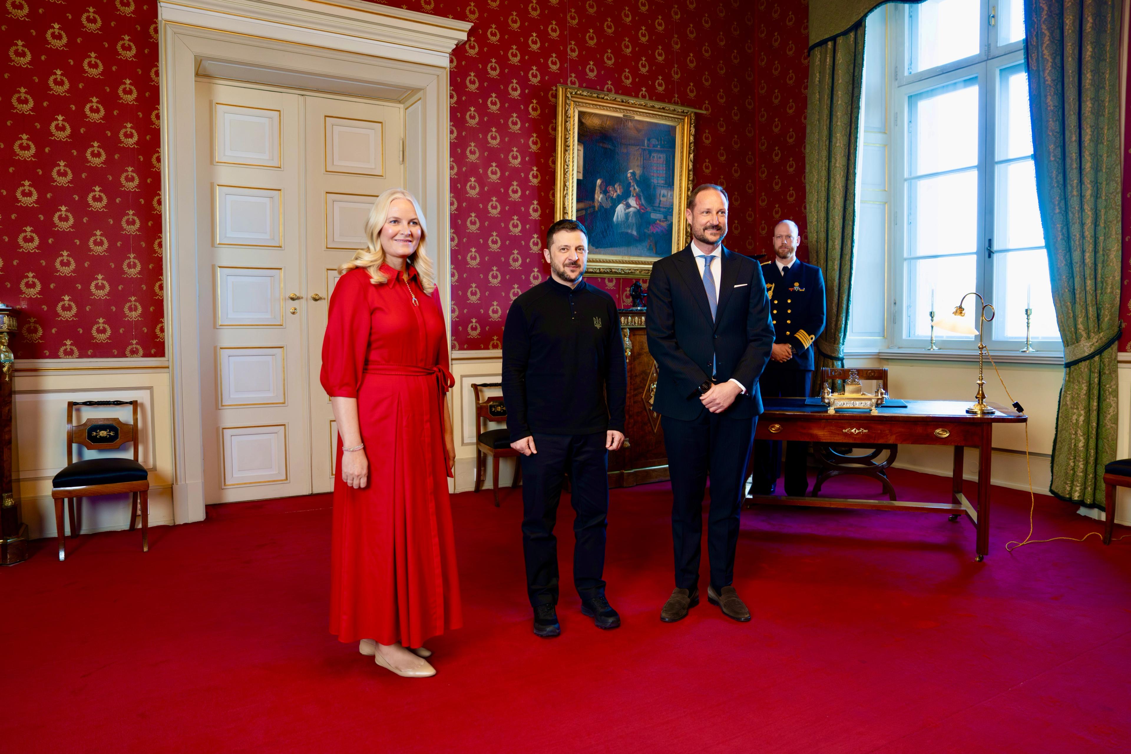 President Zelenskyj står mellom Kronprinsen og Kronprinsessen for offisiell fotografering.