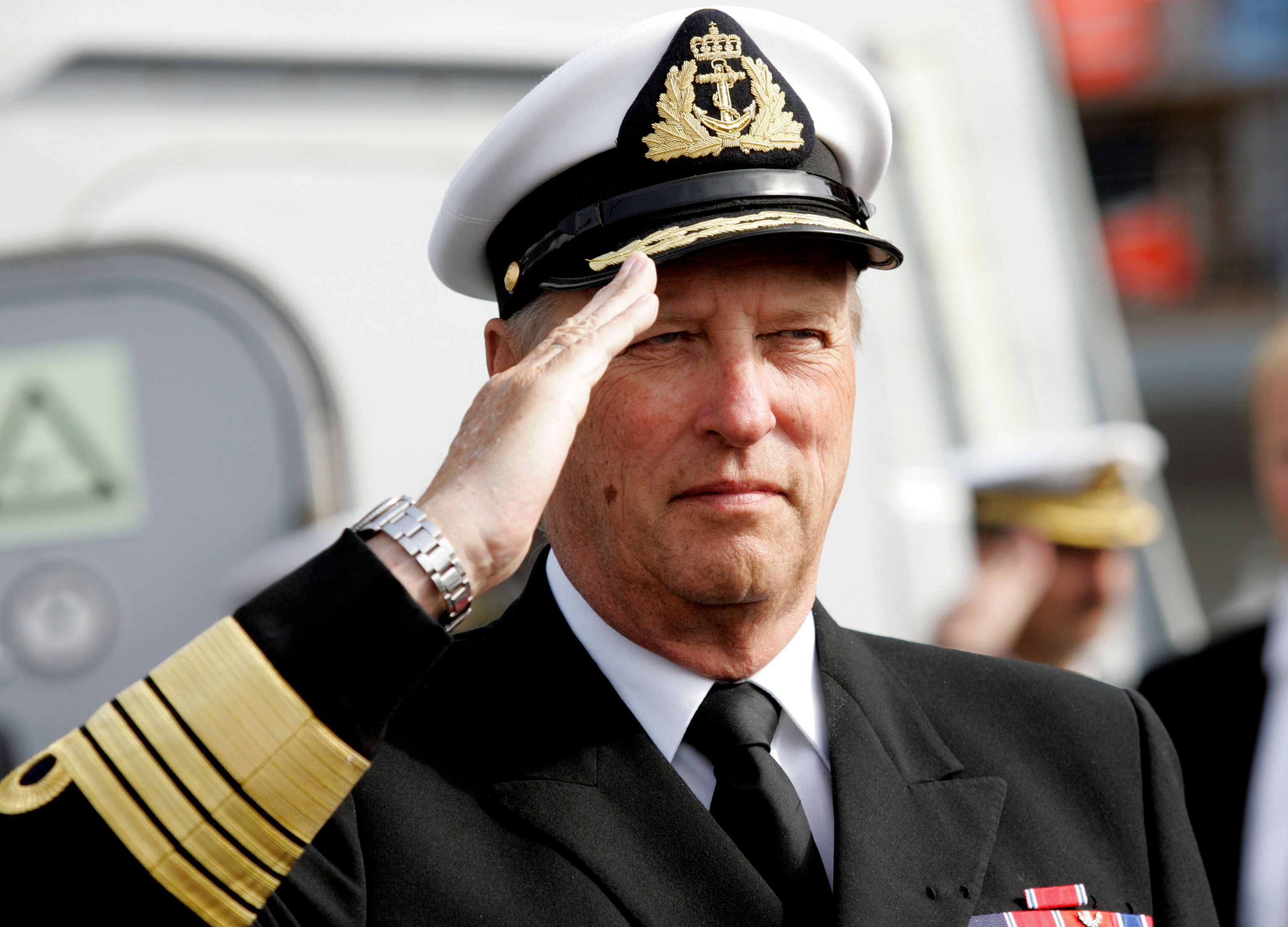 Kong Harald iført Sjøforsvarets uniform, hilser til lua.