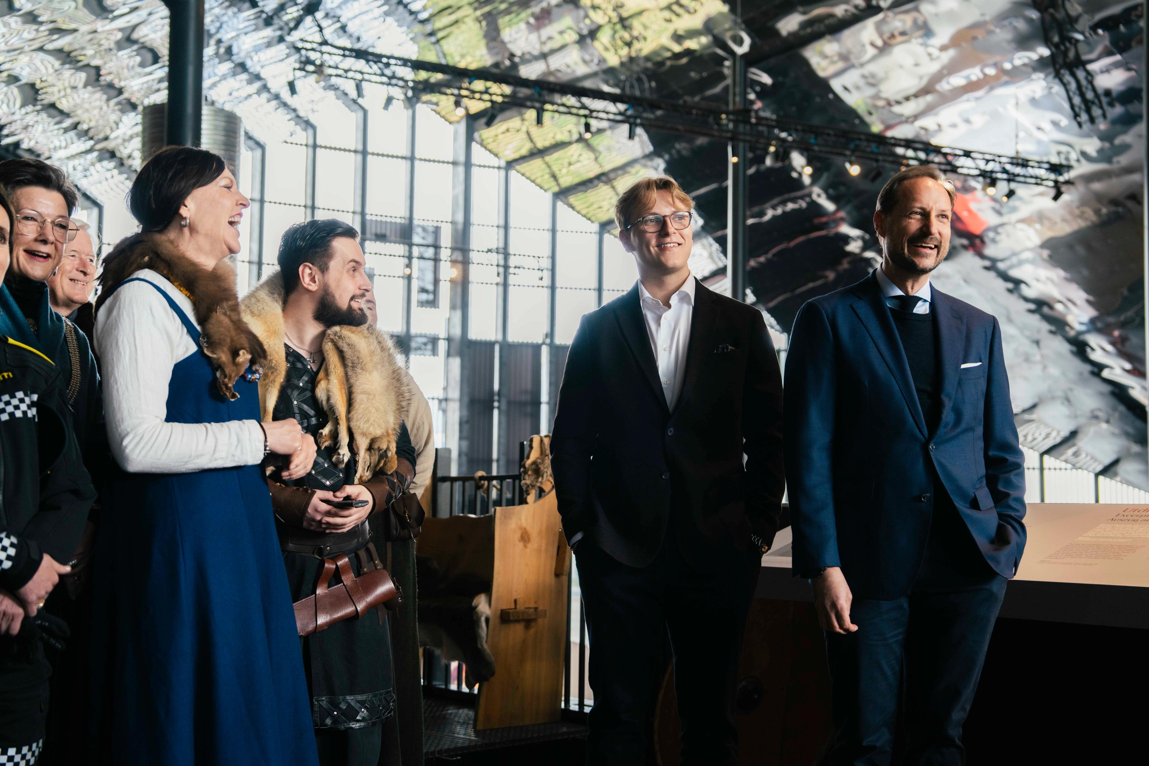 Prins Sverre Magnus og Kronprins Haakon står inne på Sagastad sammen med et følge kledd i vikingklær