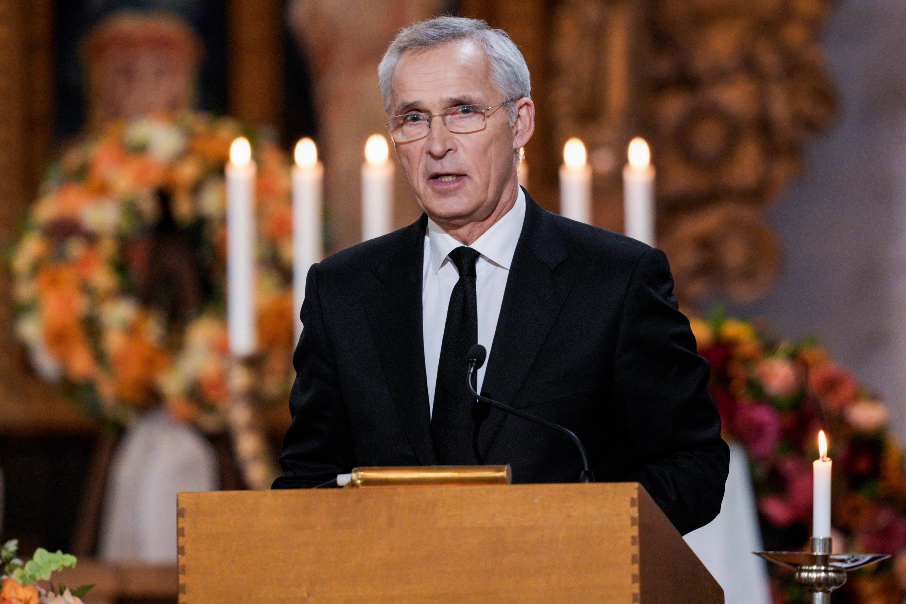 Stoltenberg i sort dress på talerstolen.