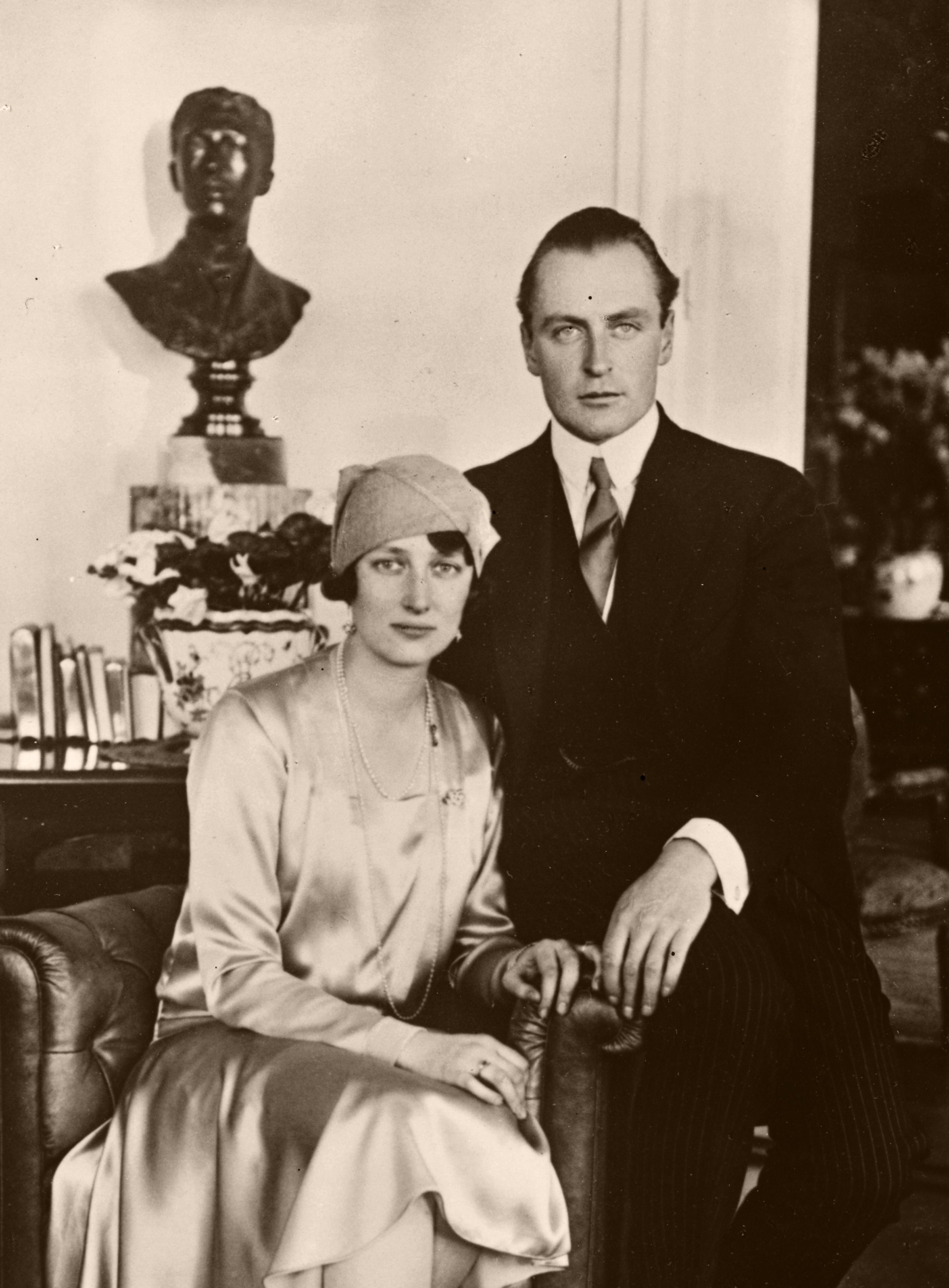 Paret sitter sammen. Prinsesse Märtha lener seg mot Kronprins Olav.