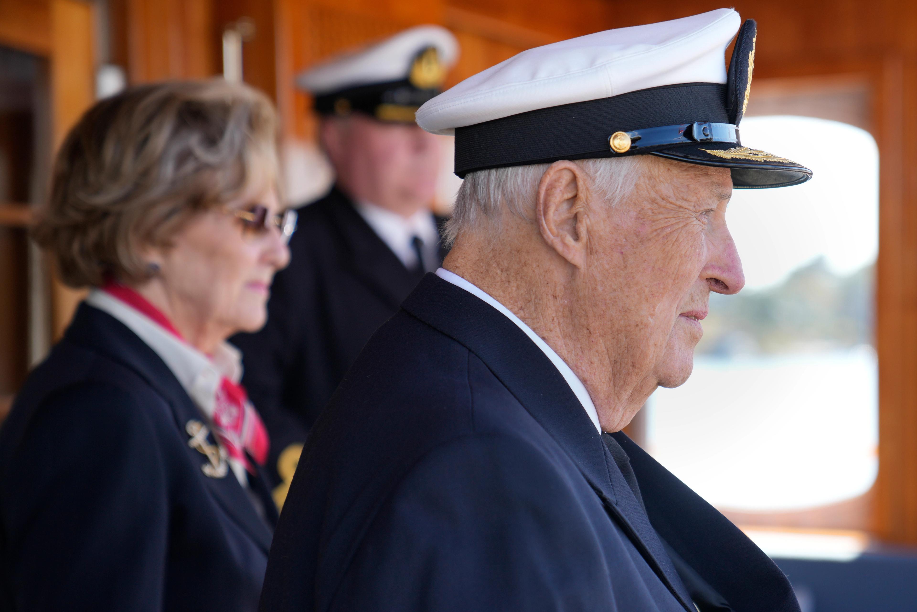 Tett på Kong Harald med båtslua på. Bak står Dronning Sonja og skipssjef Geir Aronsen.