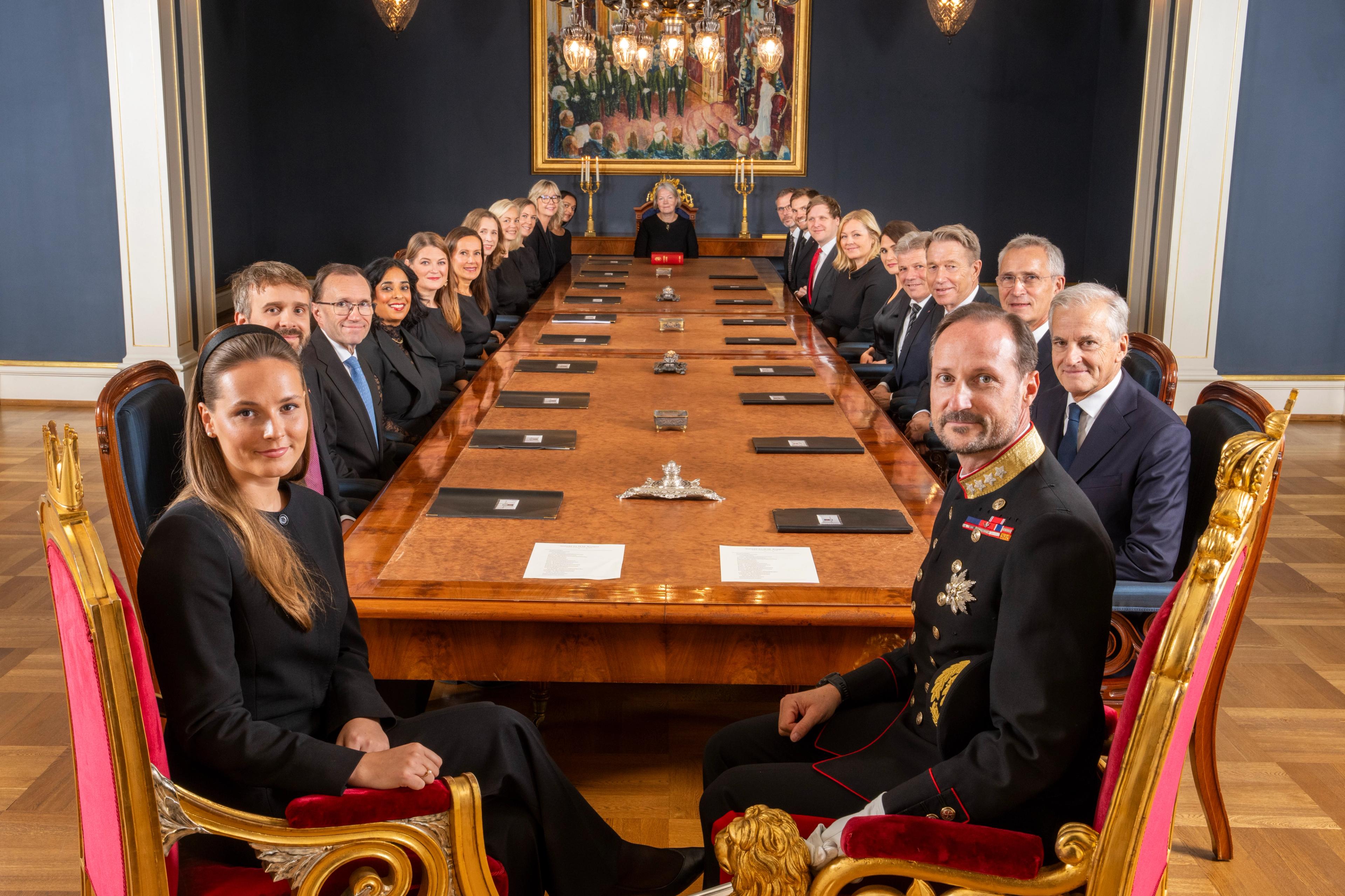 Oversiktsbilde fra Statsrådsalen. Kongen og Kronprinsessen sitter nærmest kameraet, og regjeringens medlemmer nedover på begge sider av det lange bordet.