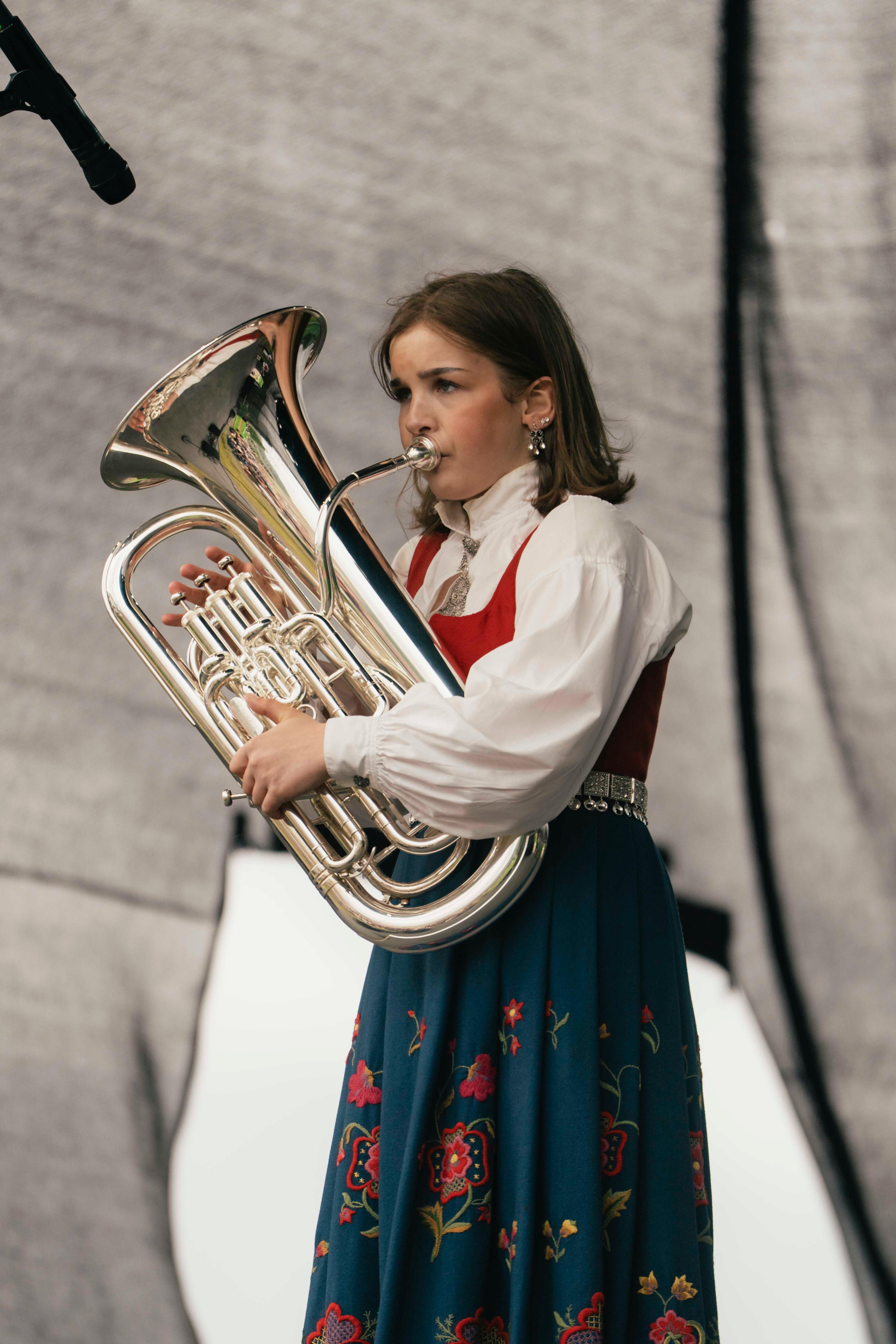 Andrine står i bunad medan ho spelar.