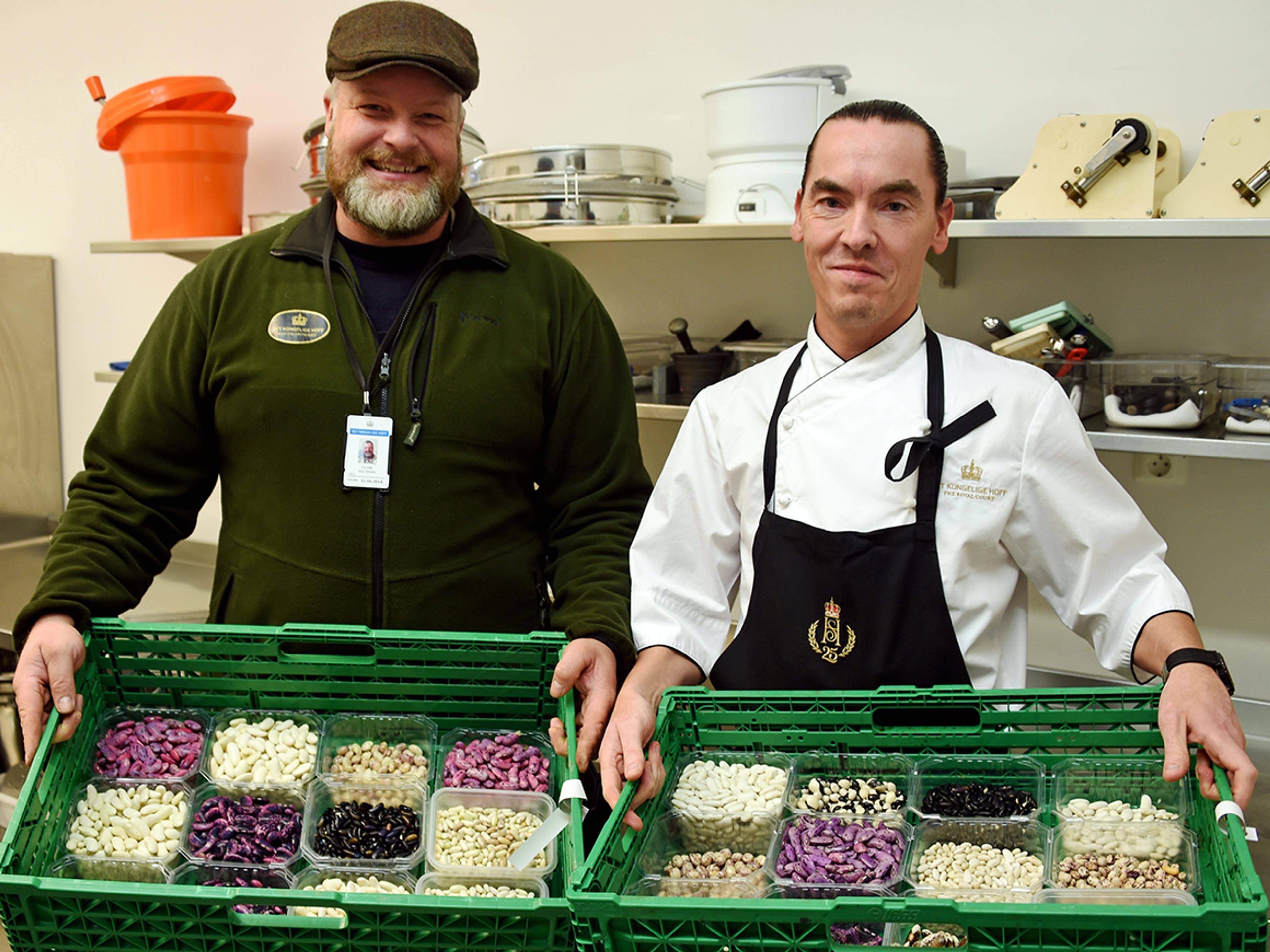 En gartner og en kokk viser fram hver sin kasse med belgfrukter.