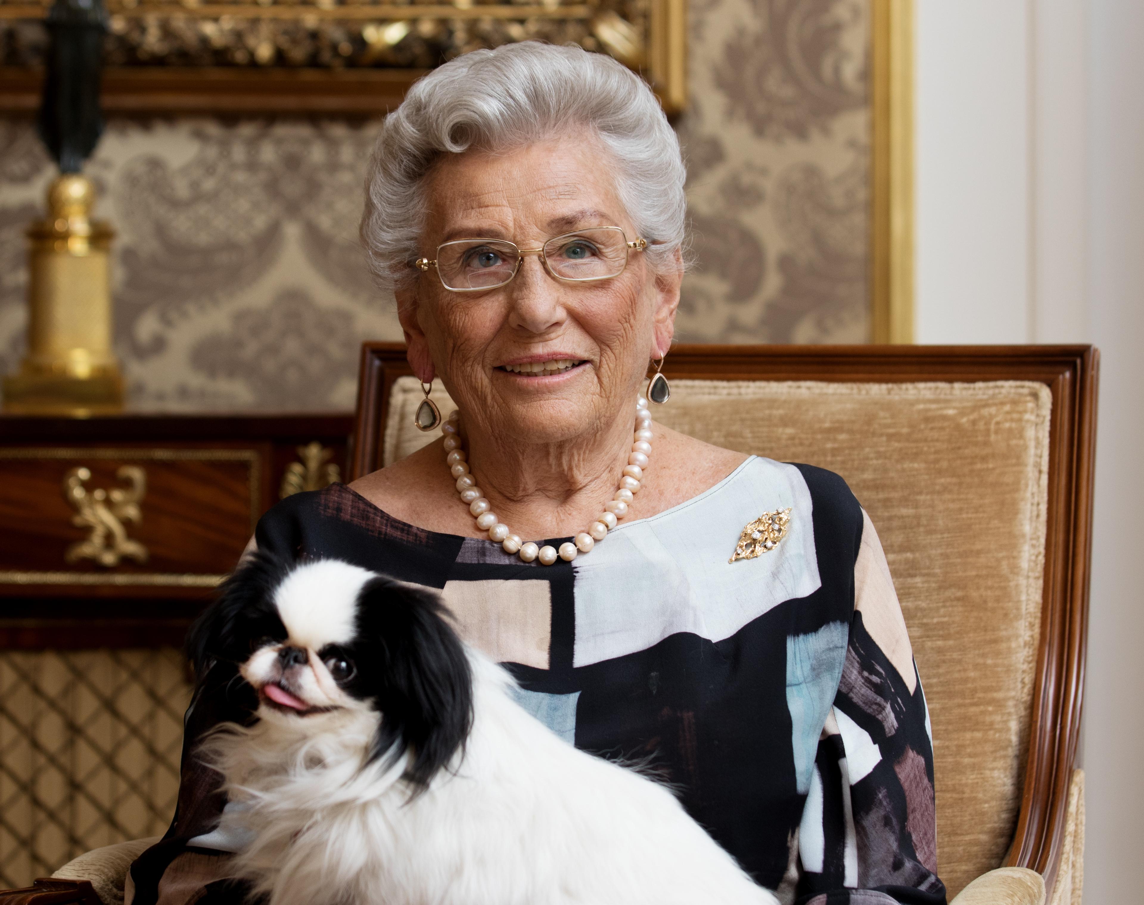 Portrett av Prinsesse Astrid sittende i stol sammen med hunden sin Tarzan.