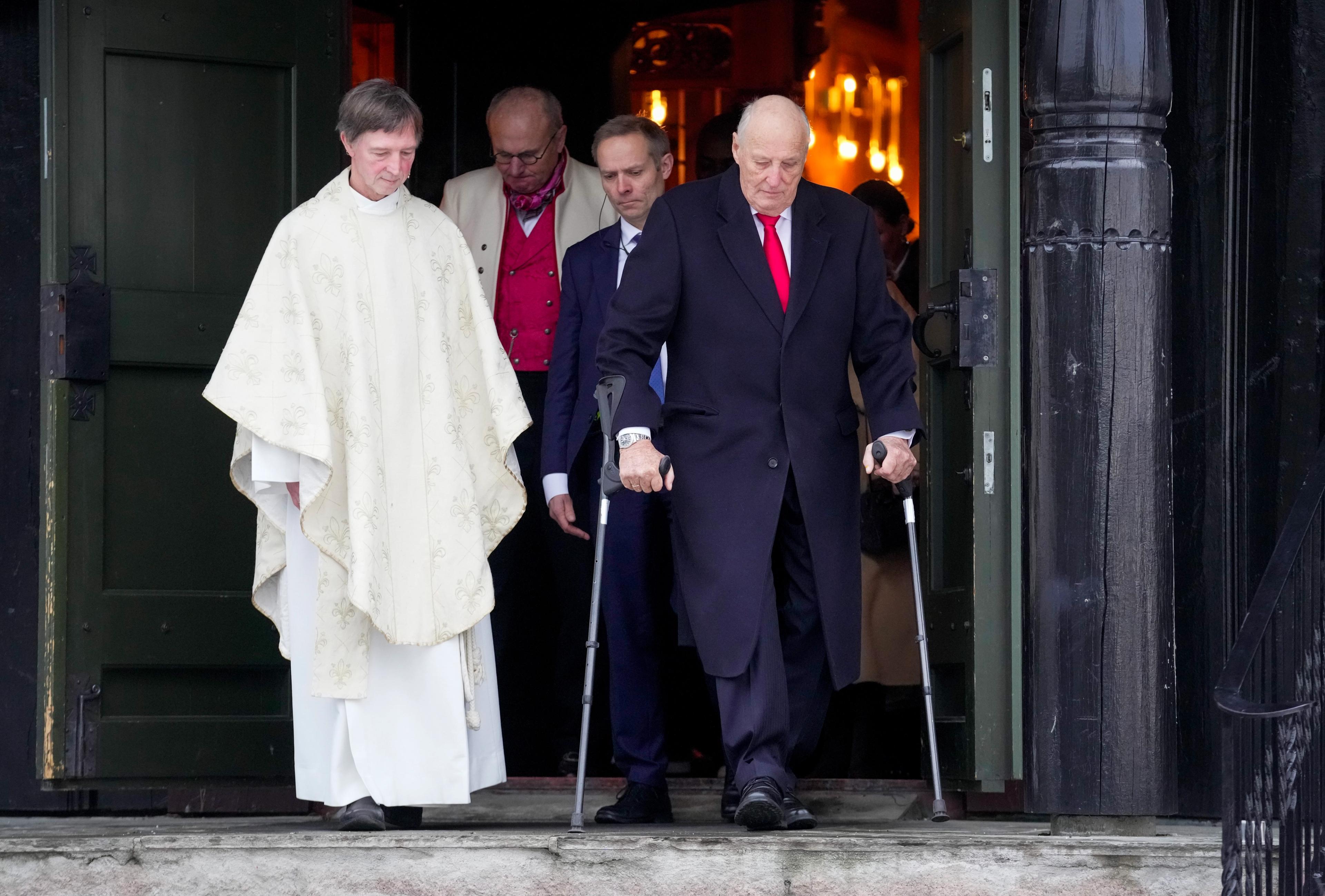 Kong Harald går ut av kyrkja i følgje med soknepresten.