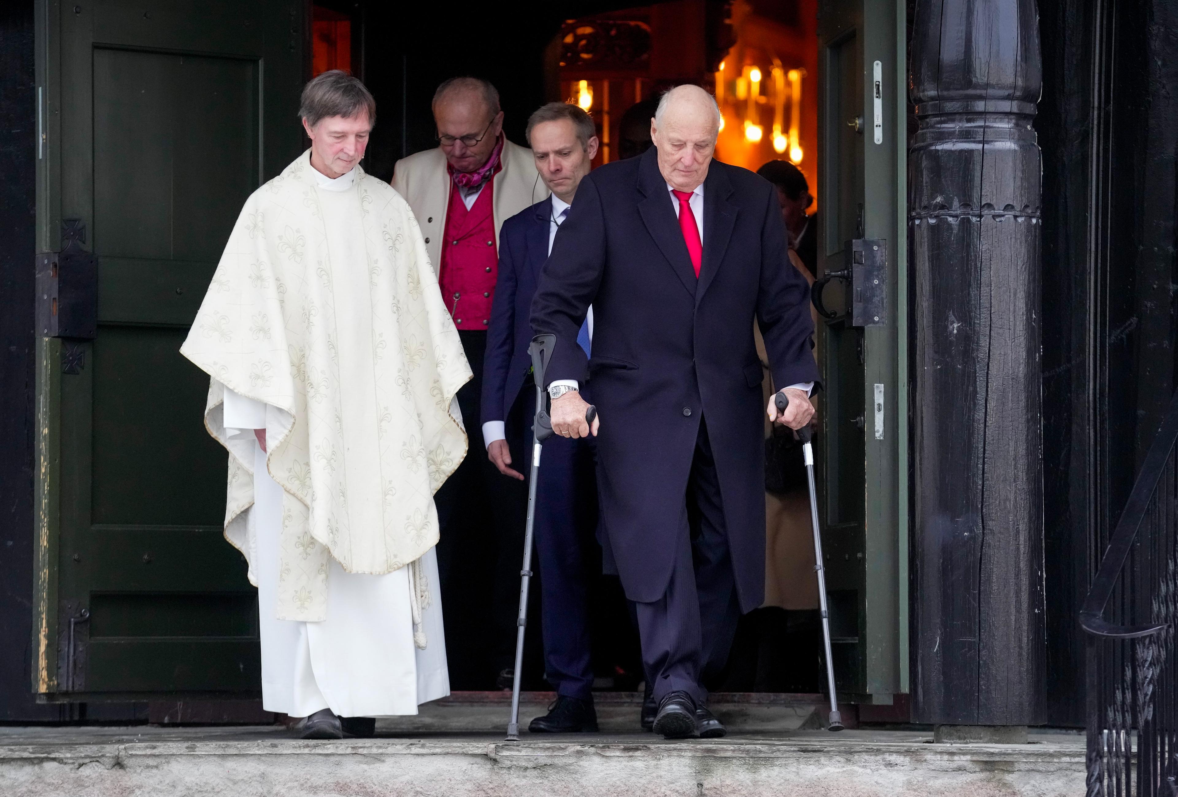 Kong Harald går ut av kyrkja i følgje med soknepresten.