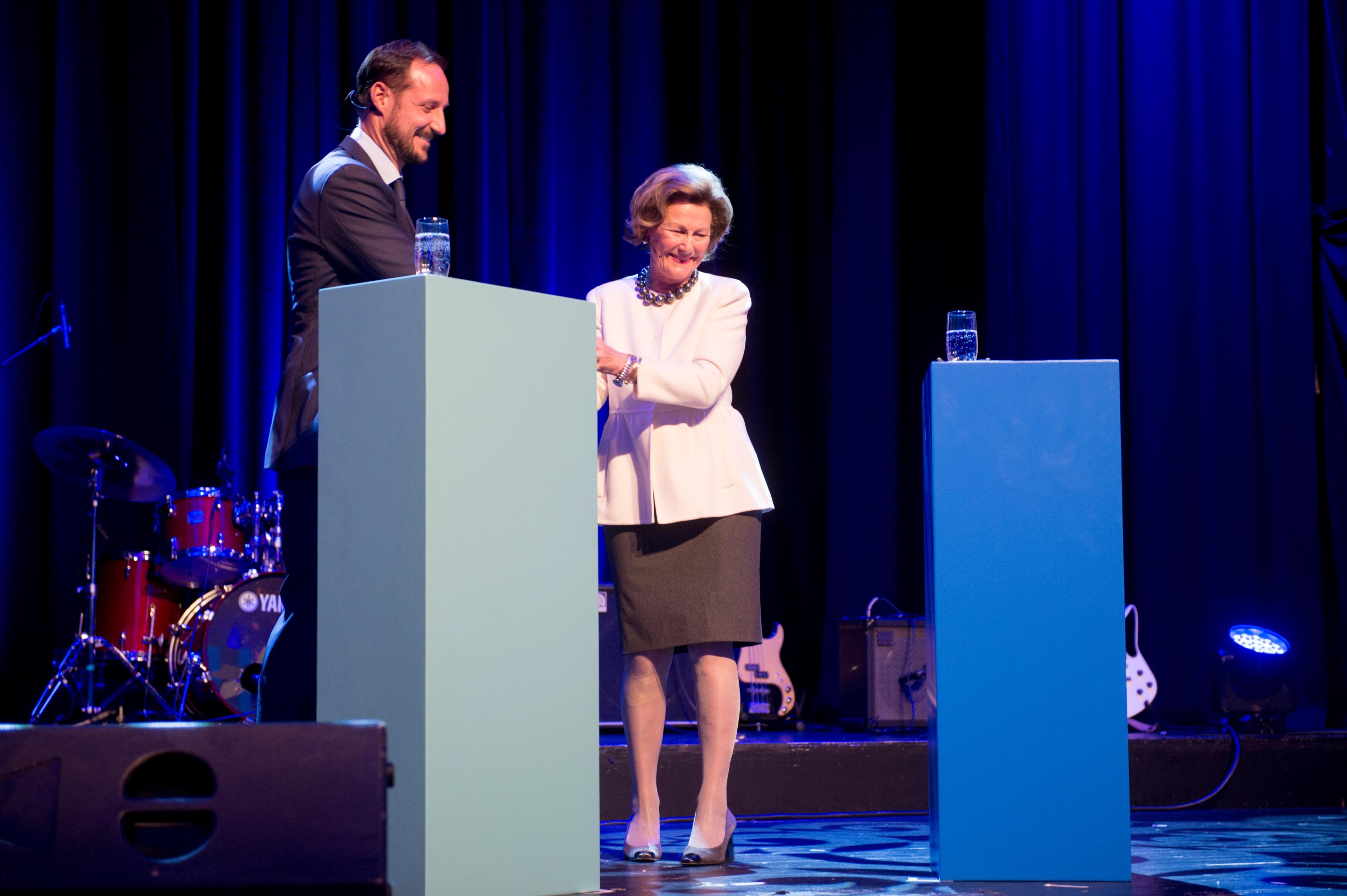 Dronning Sonja og Kronprins Haakon står sammen på scenen.