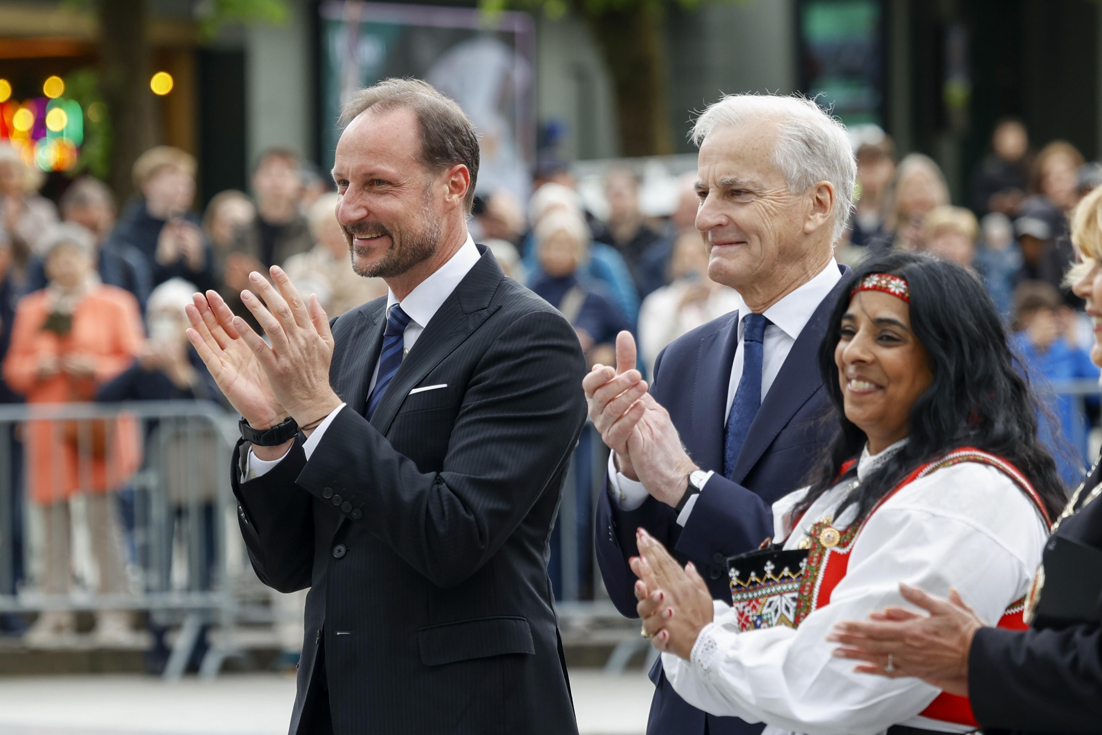 Alle tre står smilende og klapper.