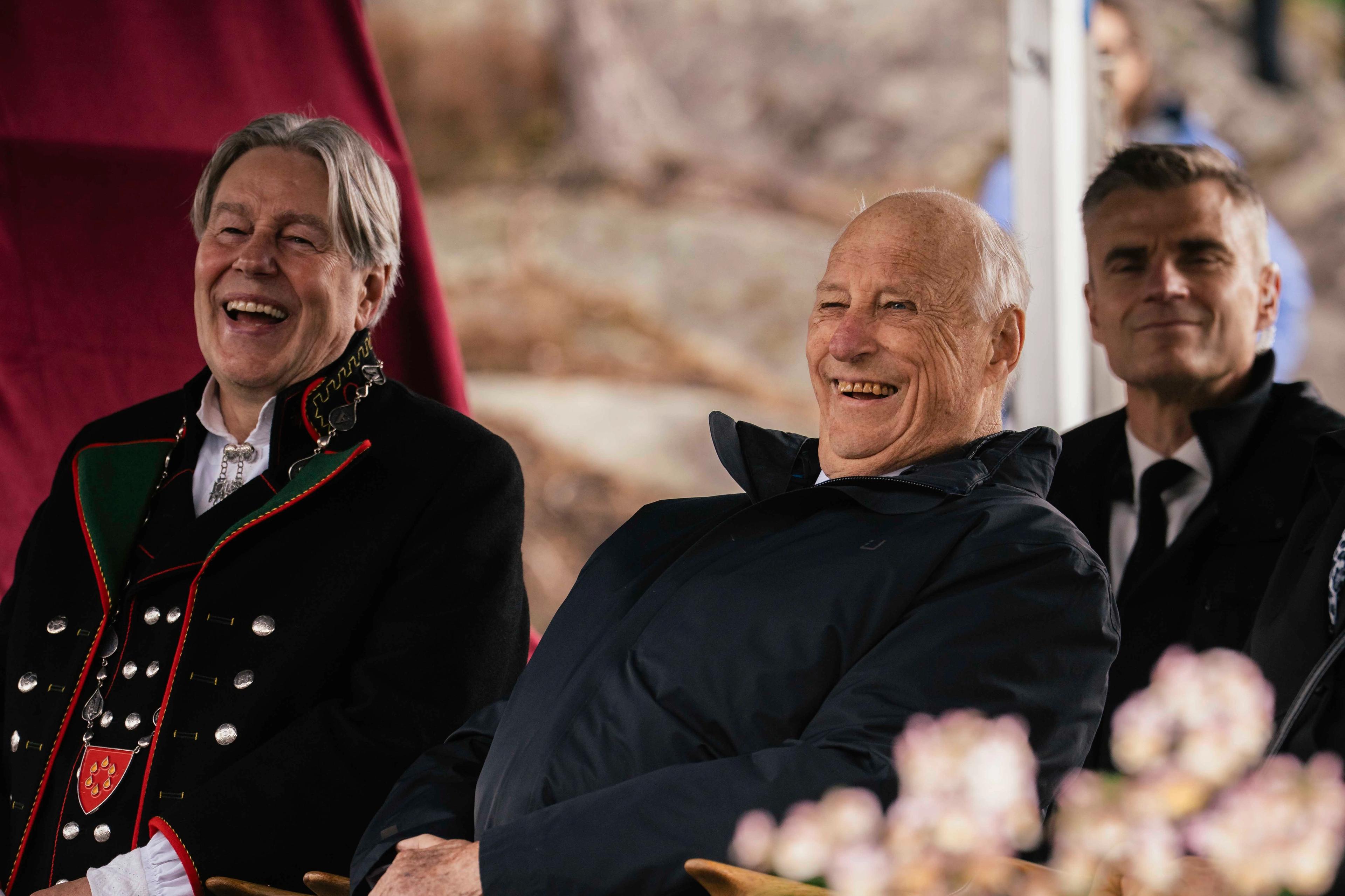 Kong Harald og ordføraren ler av underhaldninga.