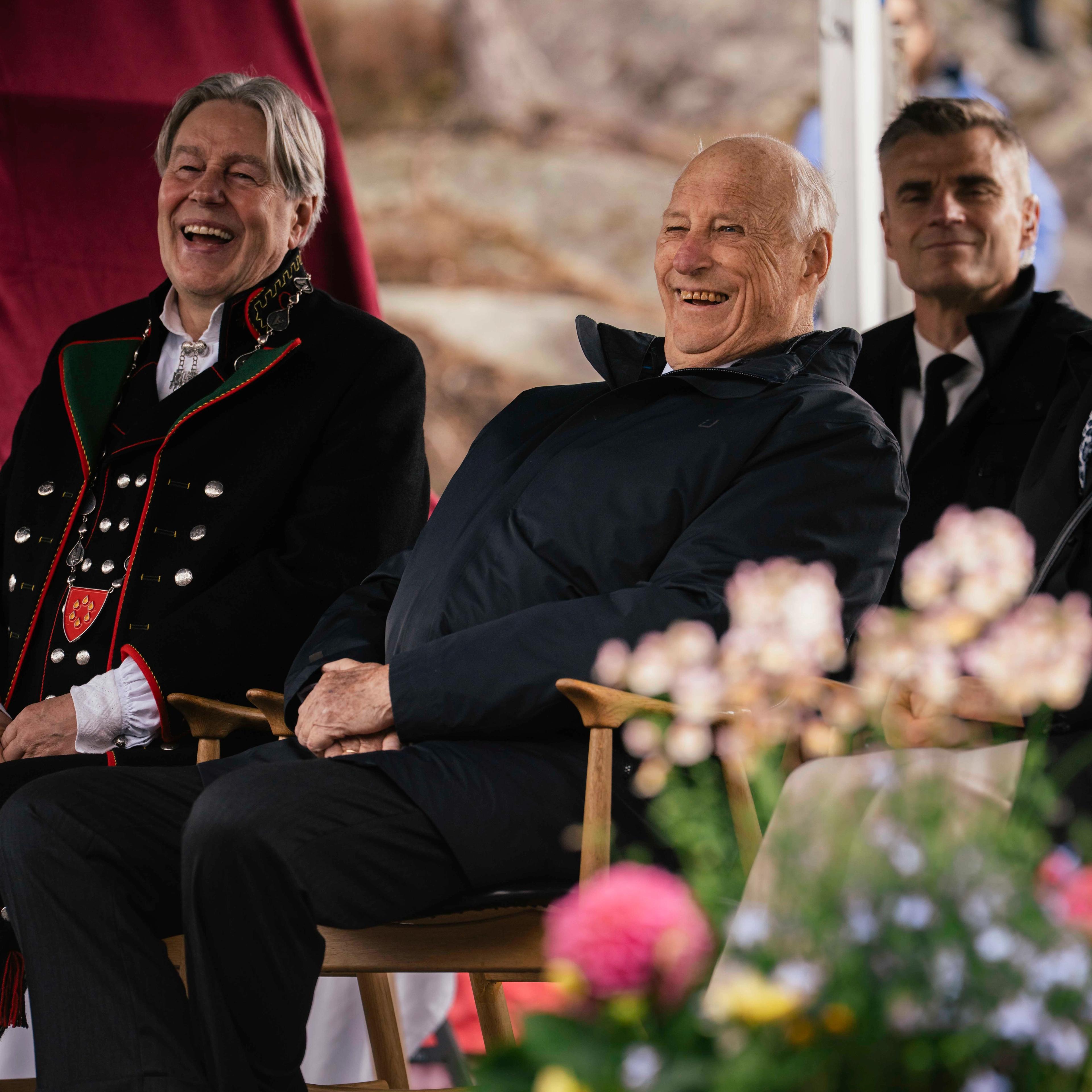 Kong Harald og ordføraren ler av underhaldninga.